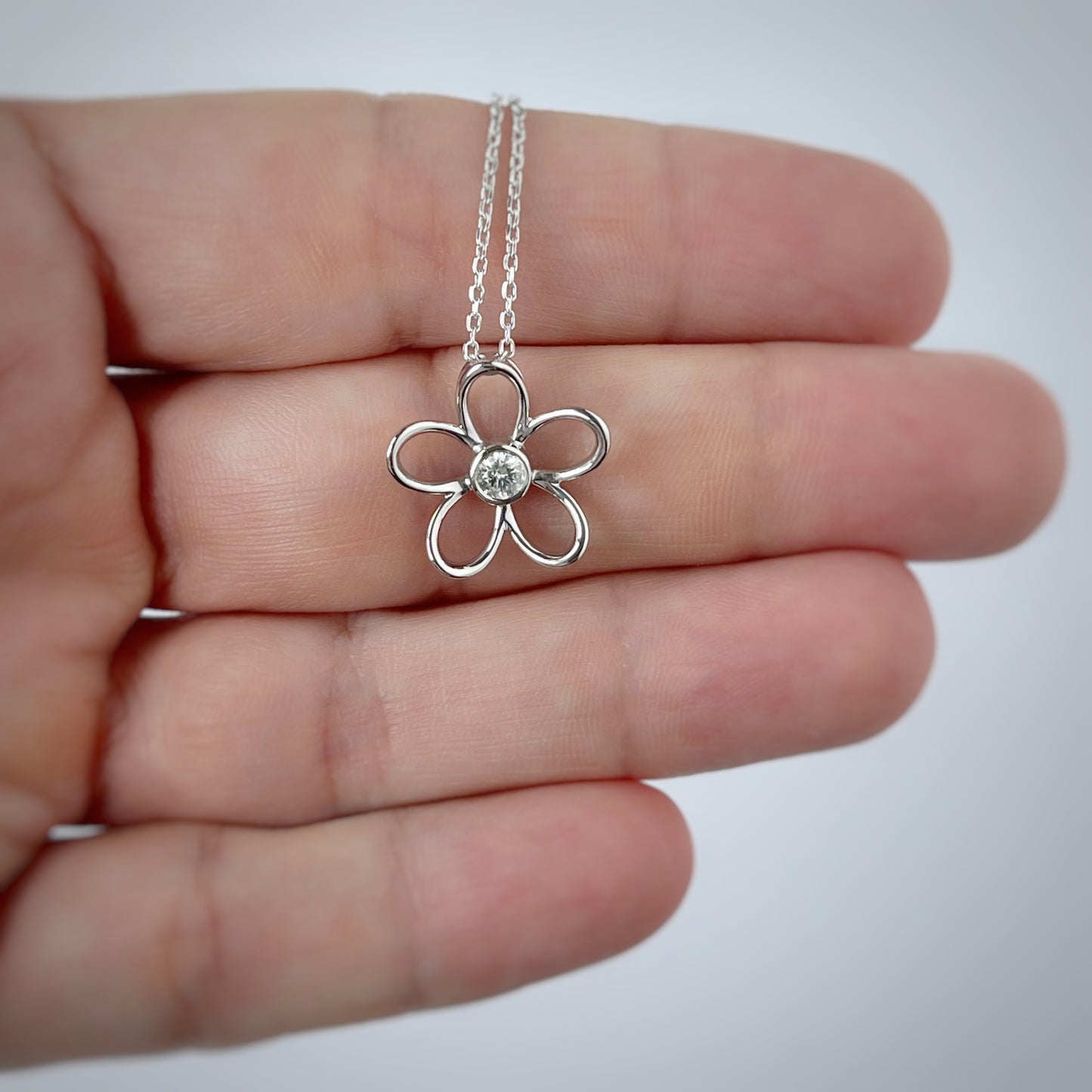 Collar en plata con dije de flor delineada y diamante central 0.10ct