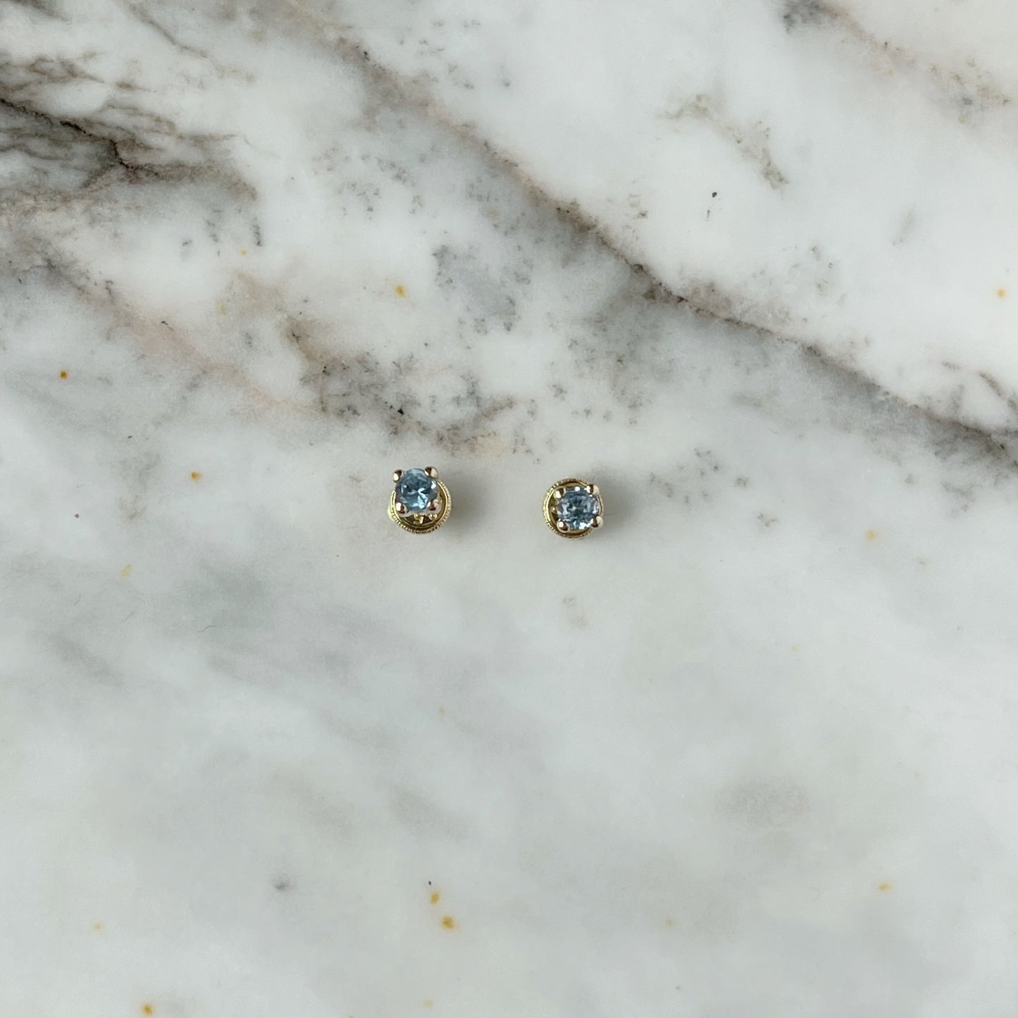 Aretes en oro amarillo 14k con circonita celeste con broche rosca