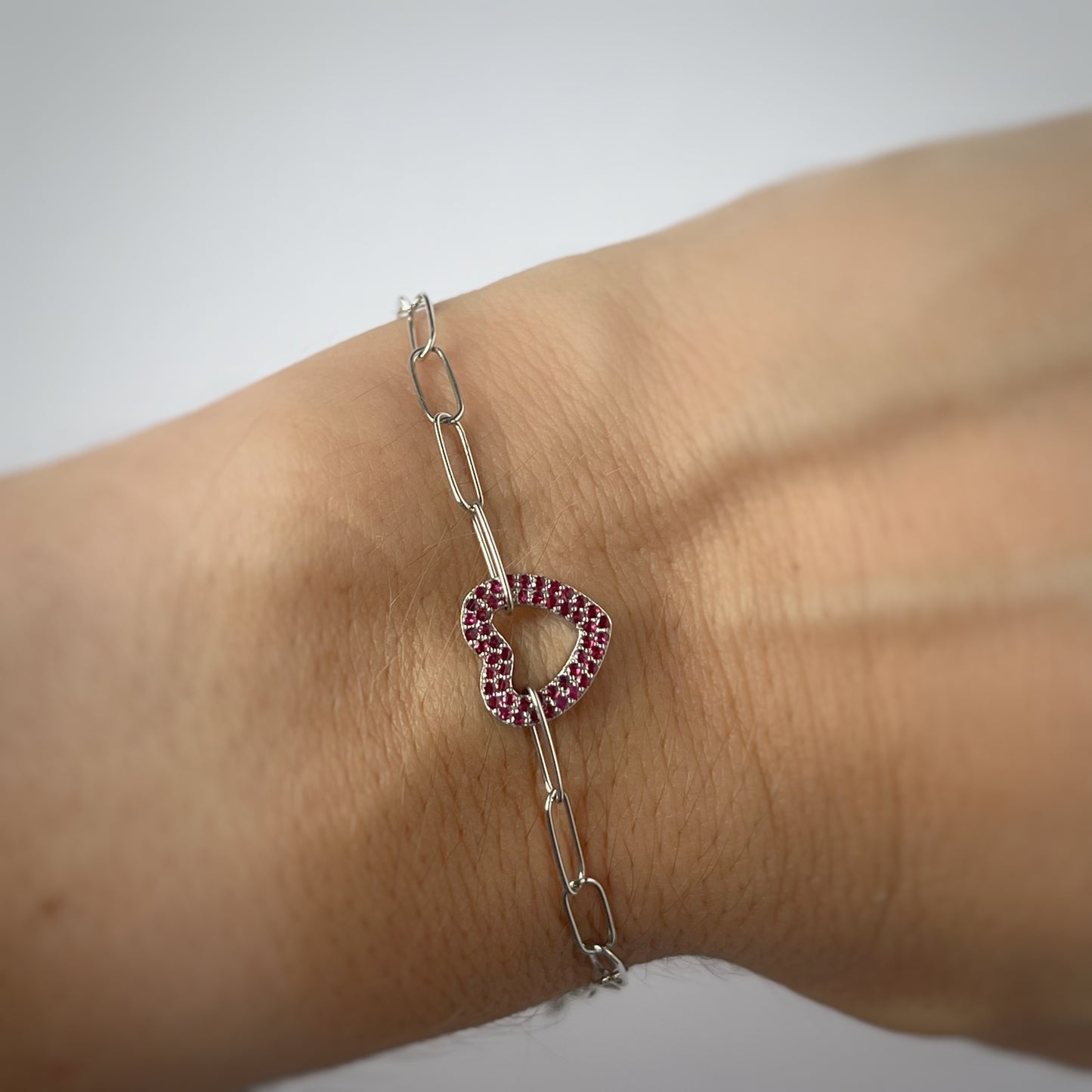 Pulsera paperclip en oro blanco 18K con dije de corazón y rubíes 0.24ctw