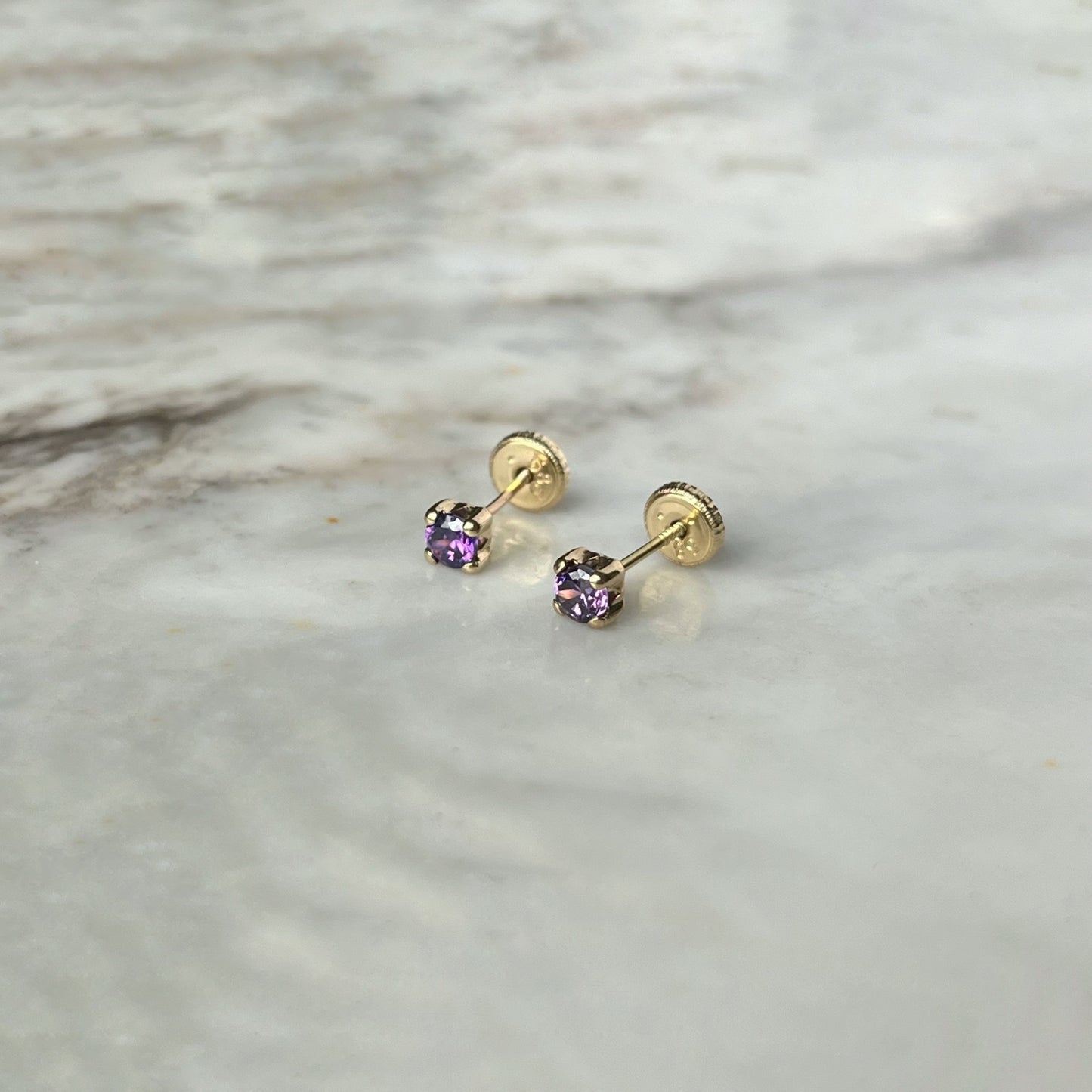 Aretes en oro amarillo 14k con circonita morada con broche rosca