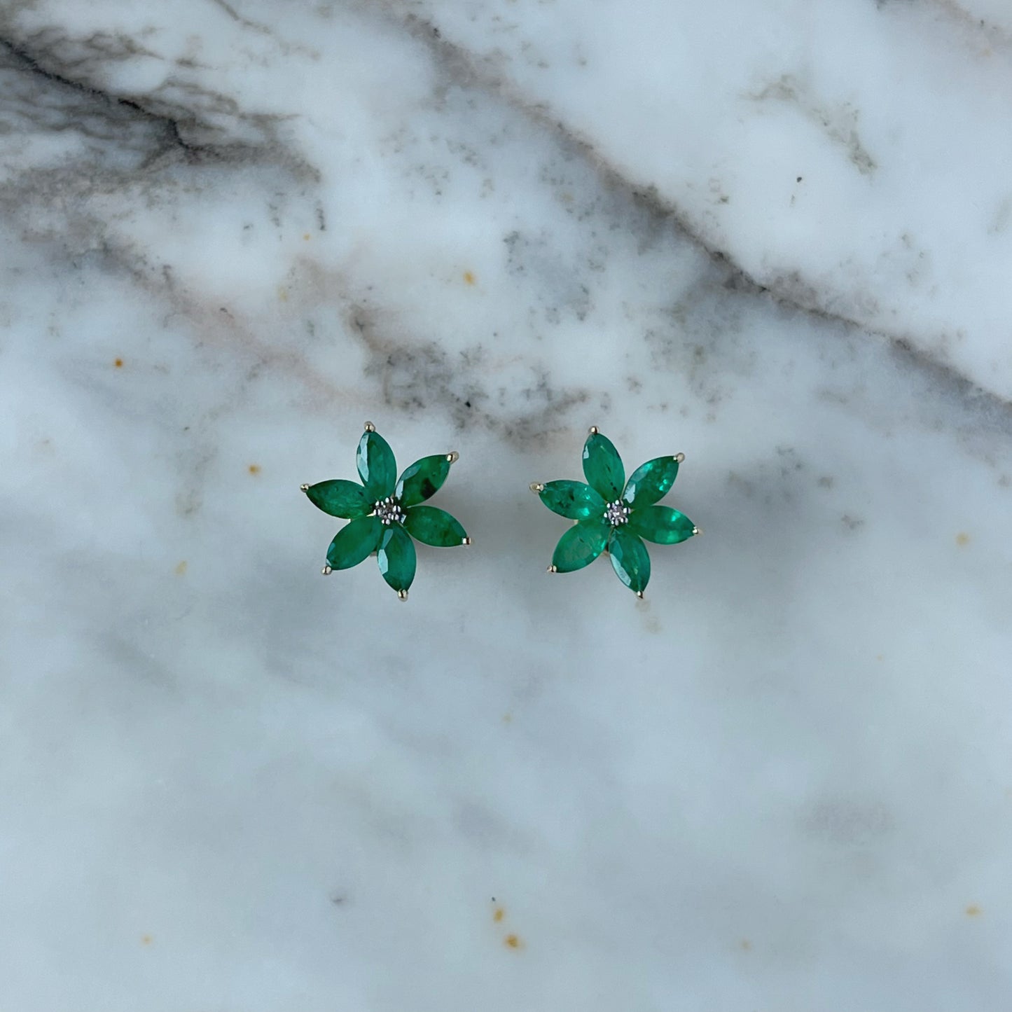 Aretes de flor de seis pétalos en oro amarillo 10K con esmeraldas y diamantes