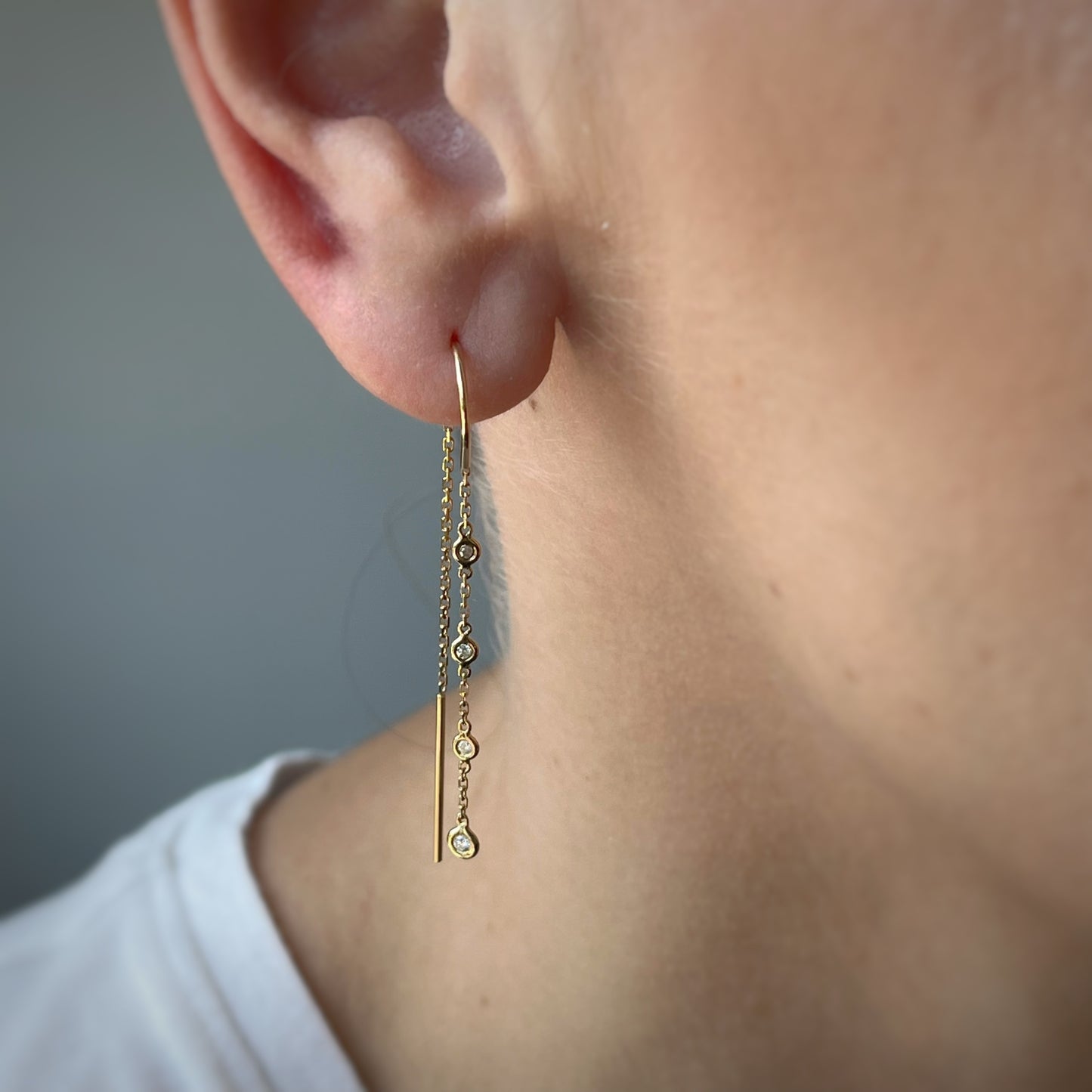Aretes en oro amarillo 14k con cadenita de diamantes colgantes 0.10ctw