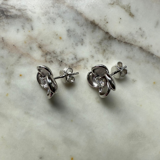 Aretes de plata con baño platino en forma de flor y circonita en el centro