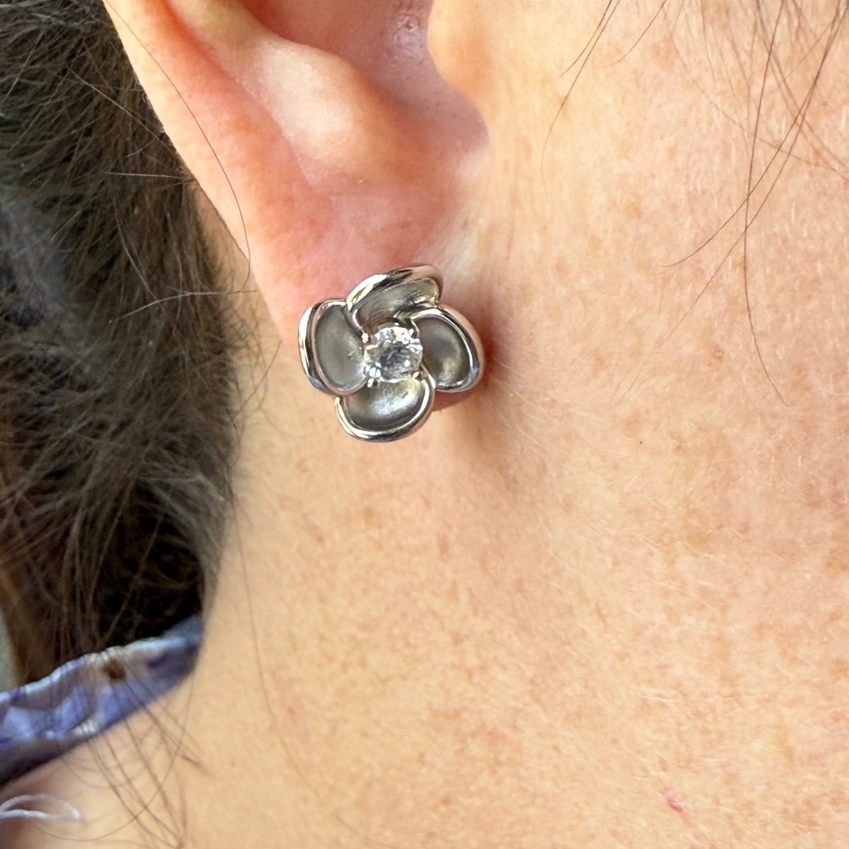 Aretes de plata con baño platino en forma de flor y circonita en el centro