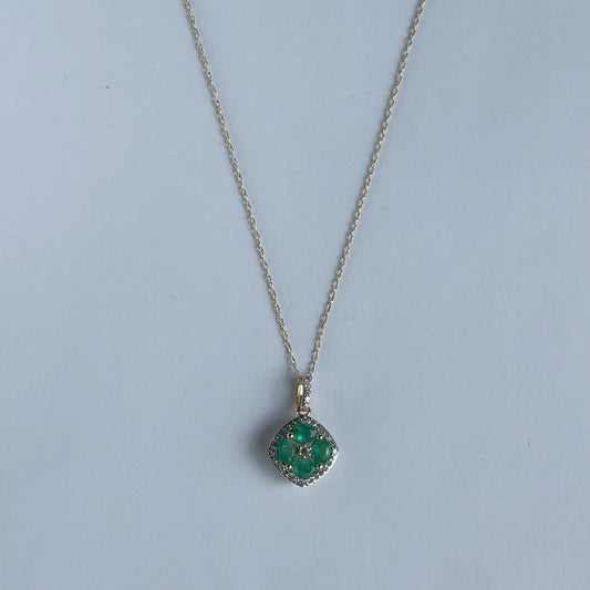 Collar en oro amarillo 14k con dije de esmeraldas en forma de flor y borde de diamantes 0.15ctw