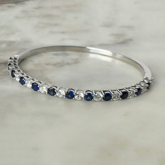 Pulsera dura de plata con baño platino y circonita blancas y azul zafiro