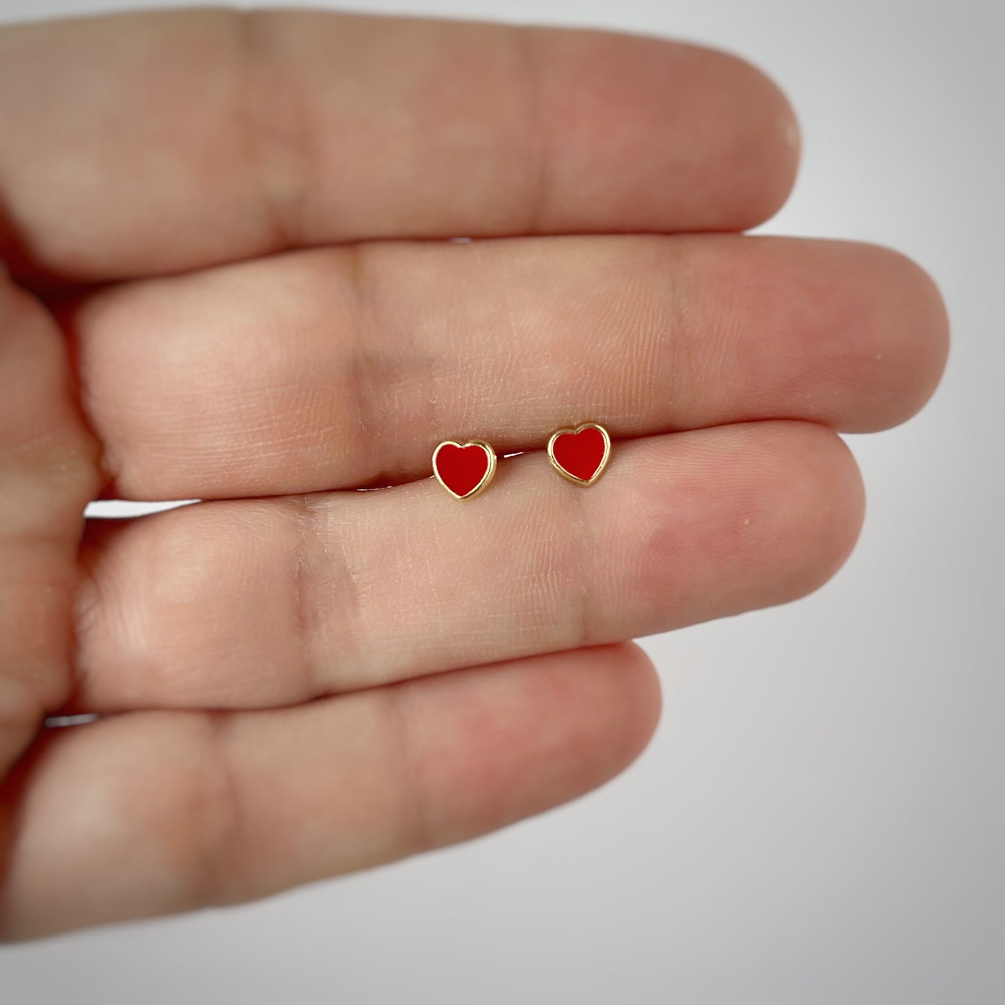Aretes en oro amarillo 14k con corazones esmaltados rojo con broche rosca