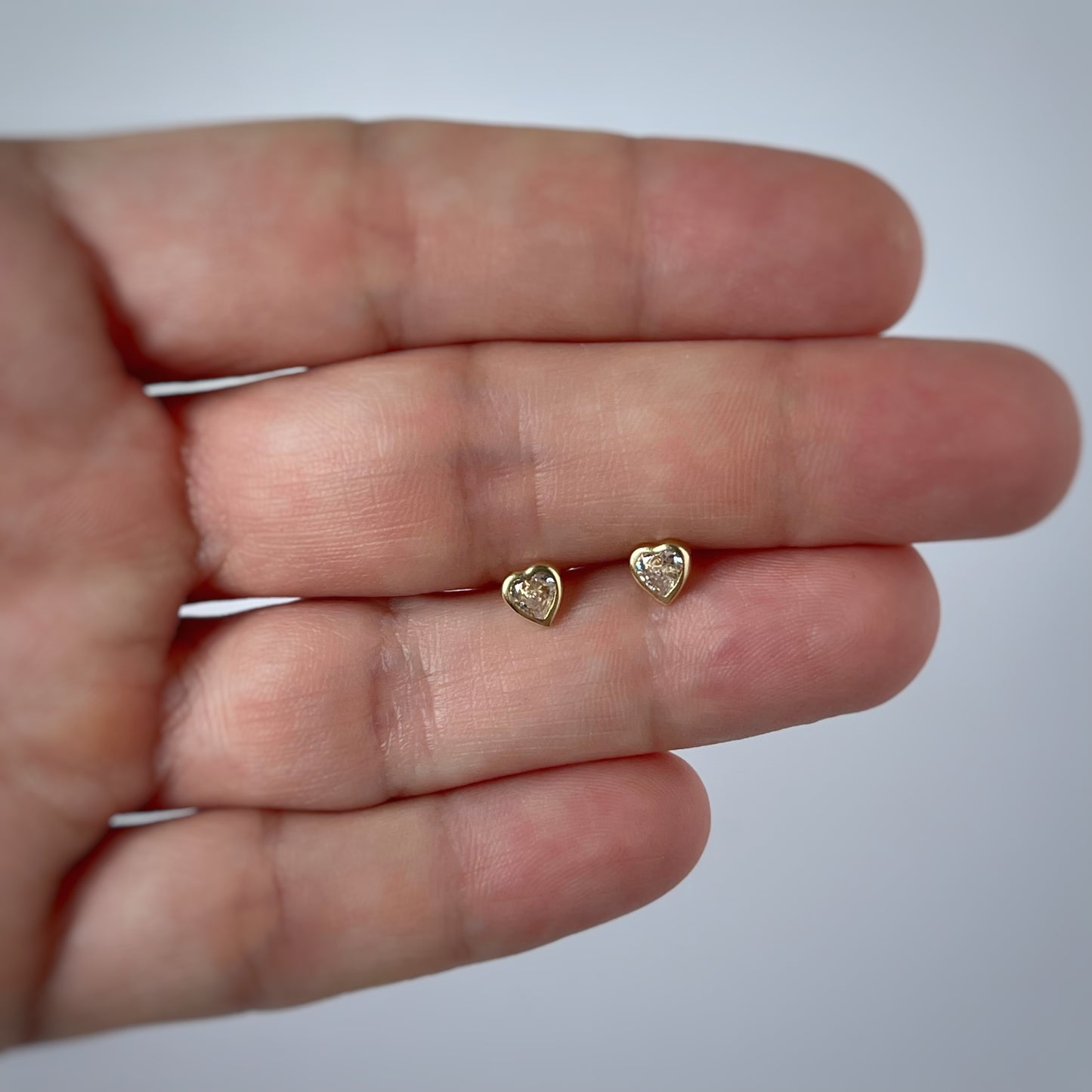 Aretes en oro amarillo 14k circonita blanca de corazón con bisel con broche rosca