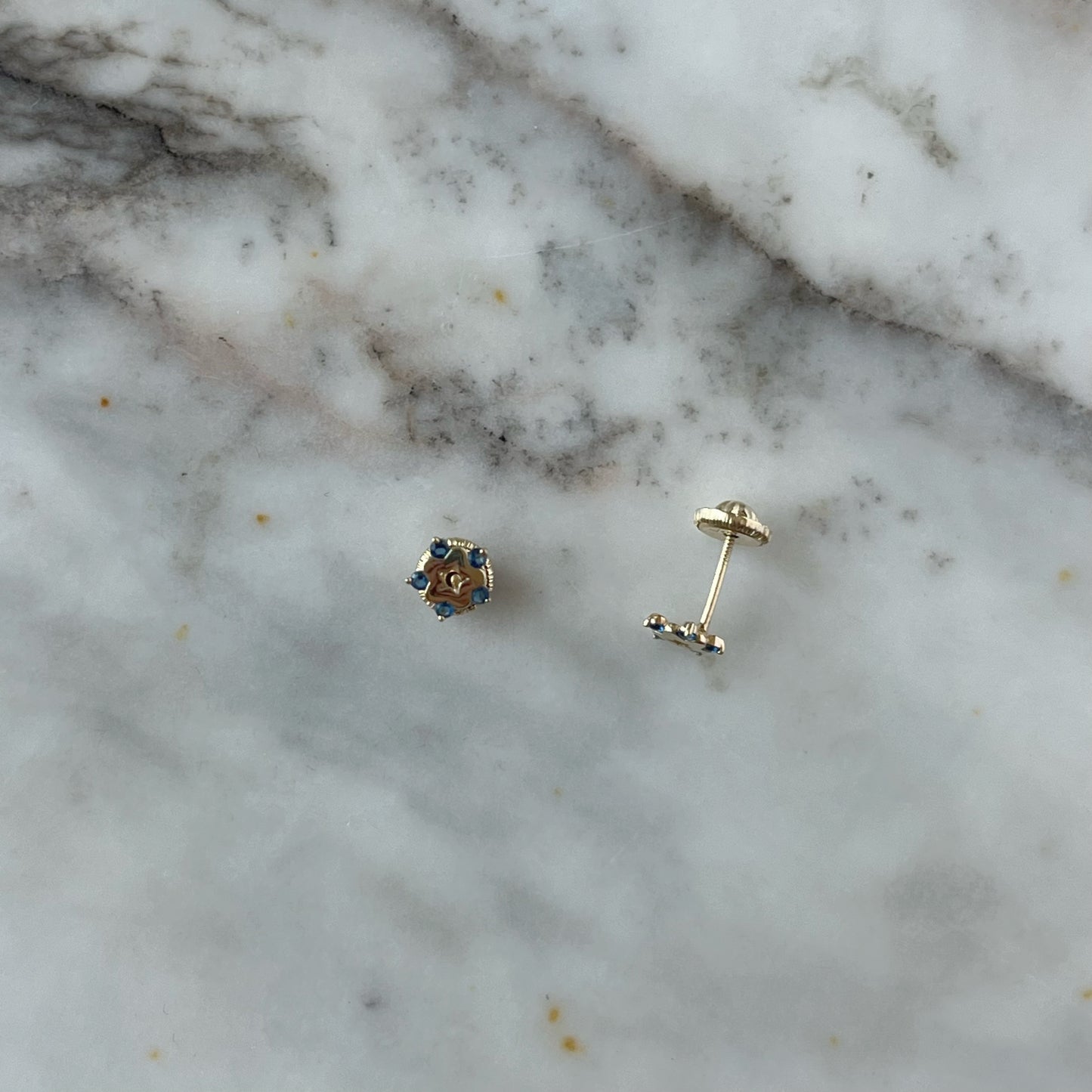 Aretes en oro amarillo de 14K con estrella tipo flor con circonita azul en los extremos y estrella calada en el centro con tope rosca