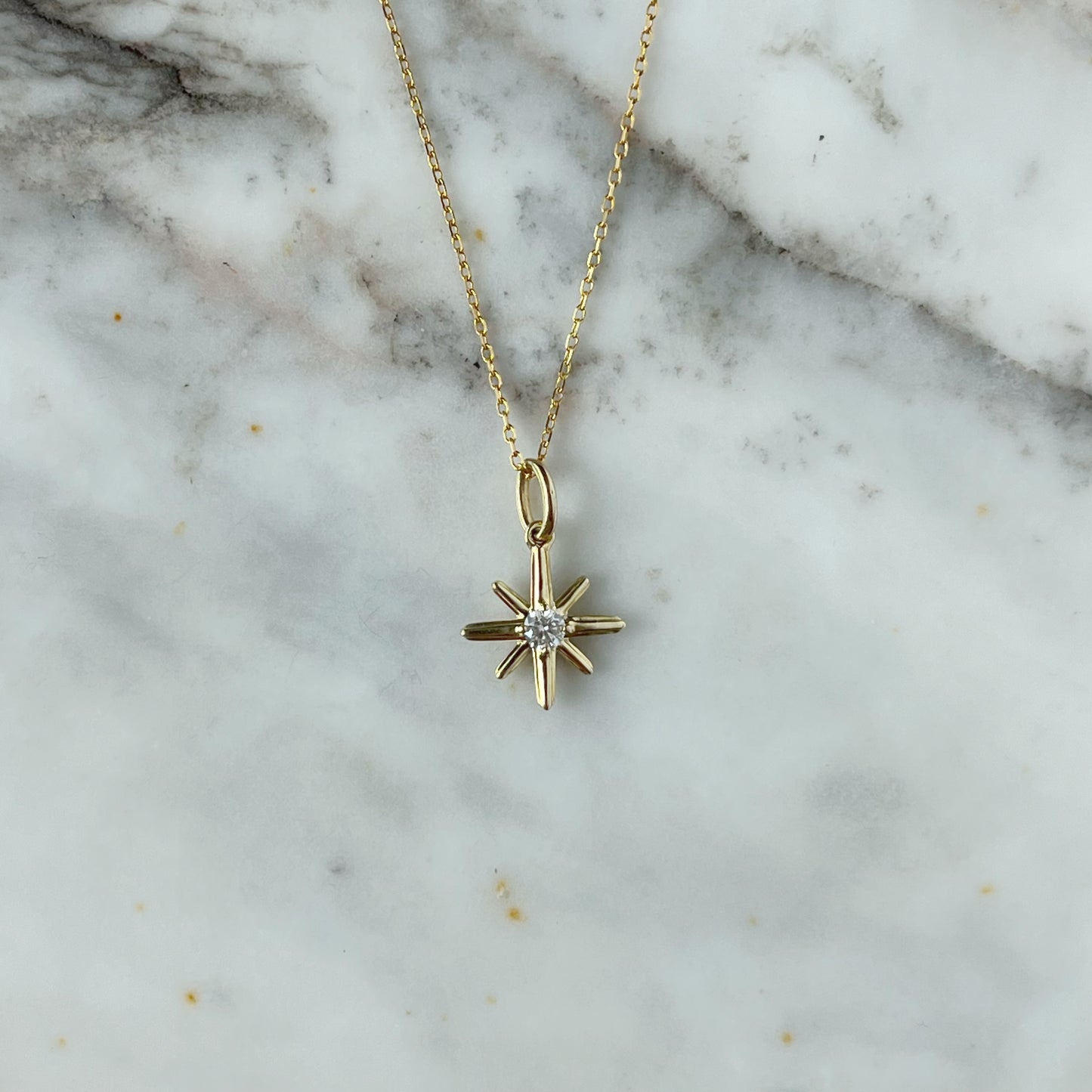 Collar en oro amarillo 10k con dije de estrella polar con diamante 0.11