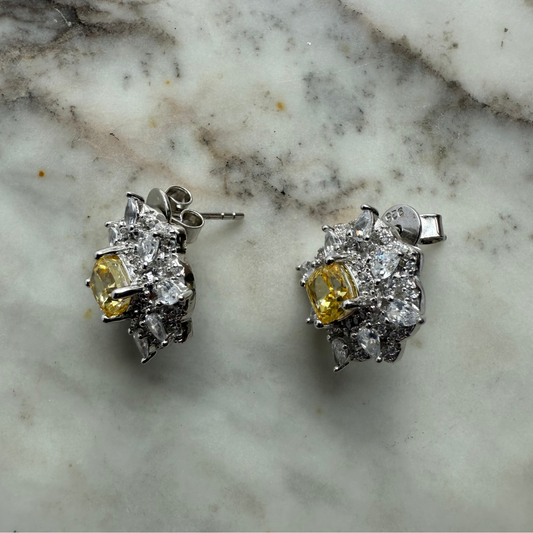 Aretes de plata con baño platino en forma de rombo con circonita amarilla en el centro