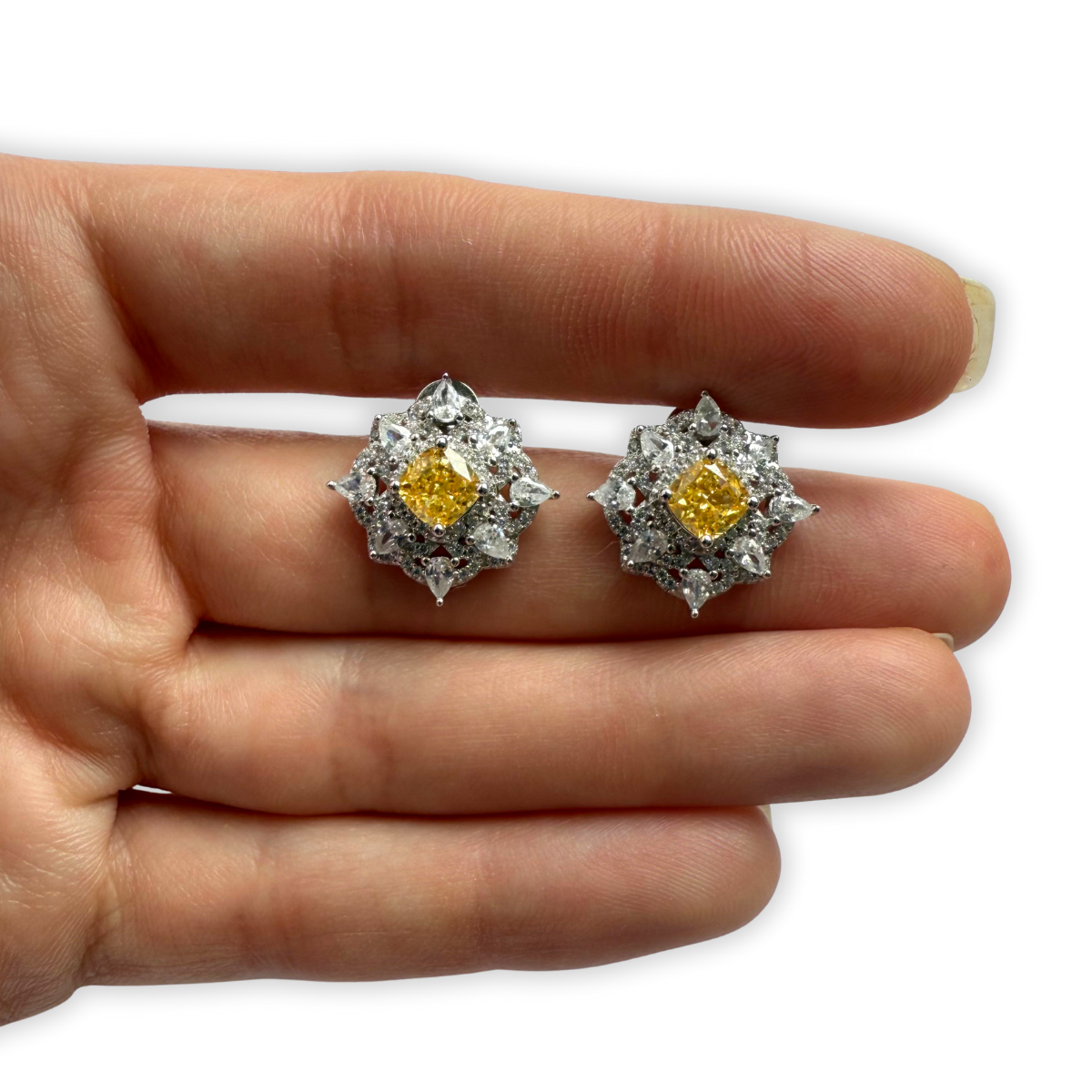 Aretes de plata con baño platino en forma de rombo con circonita amarilla en el centro