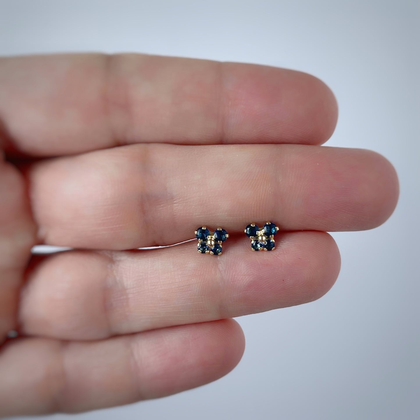 Aretes en oro amarillo 14k con mariposita de circonitas azul con broche rosca