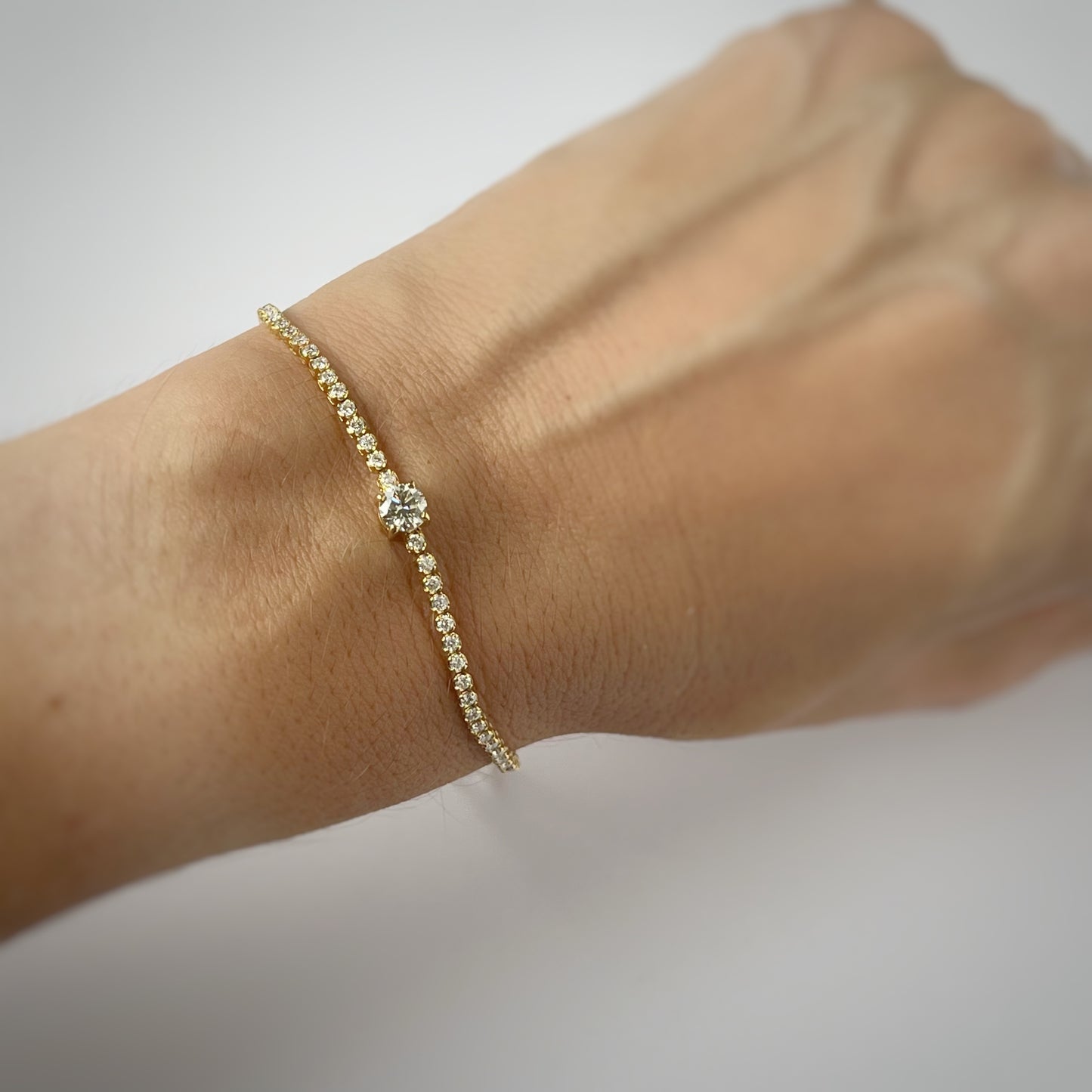 Pulsera tenis en oro amarillo 18k con diamante redondo central 1.6ctw