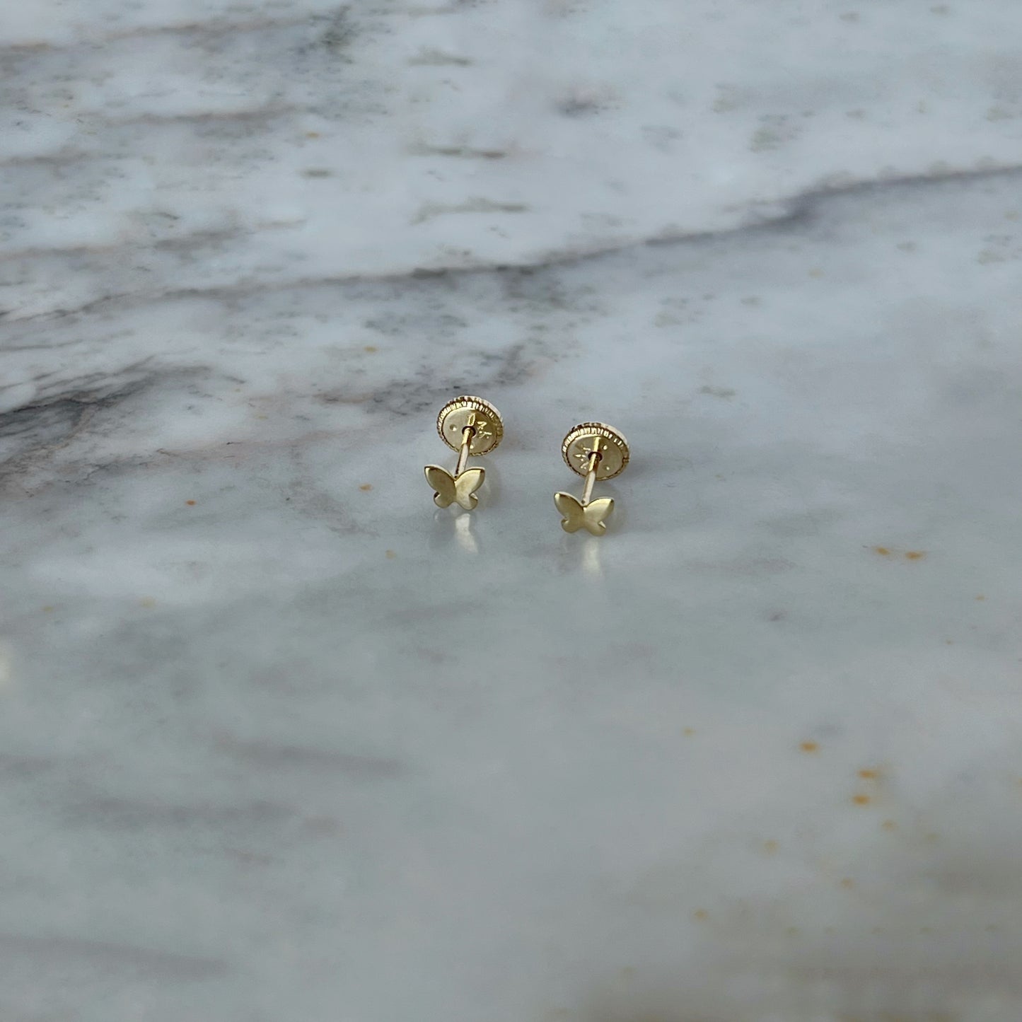 Aretes en oro amarillo 14K con mini mariposa en oro con tope rosca