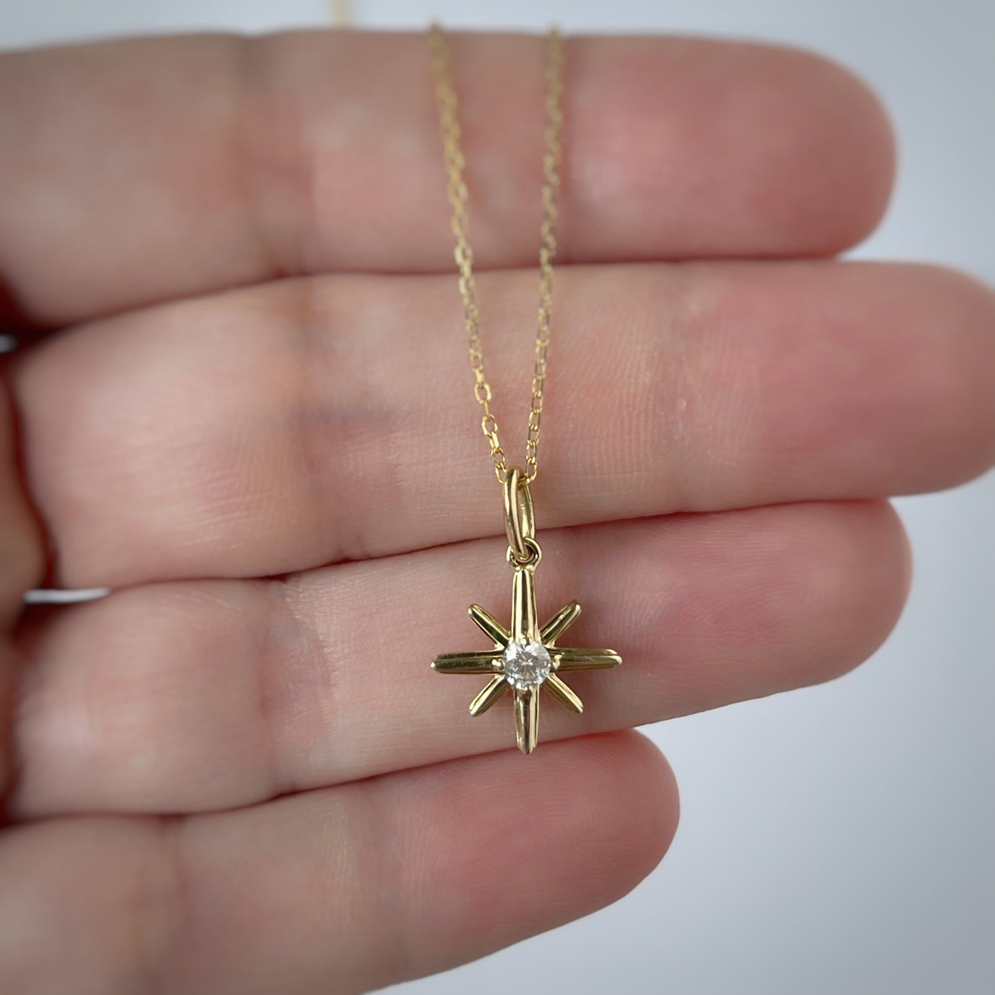 Collar en oro amarillo 10k con dije de estrella polar con diamante 0.11