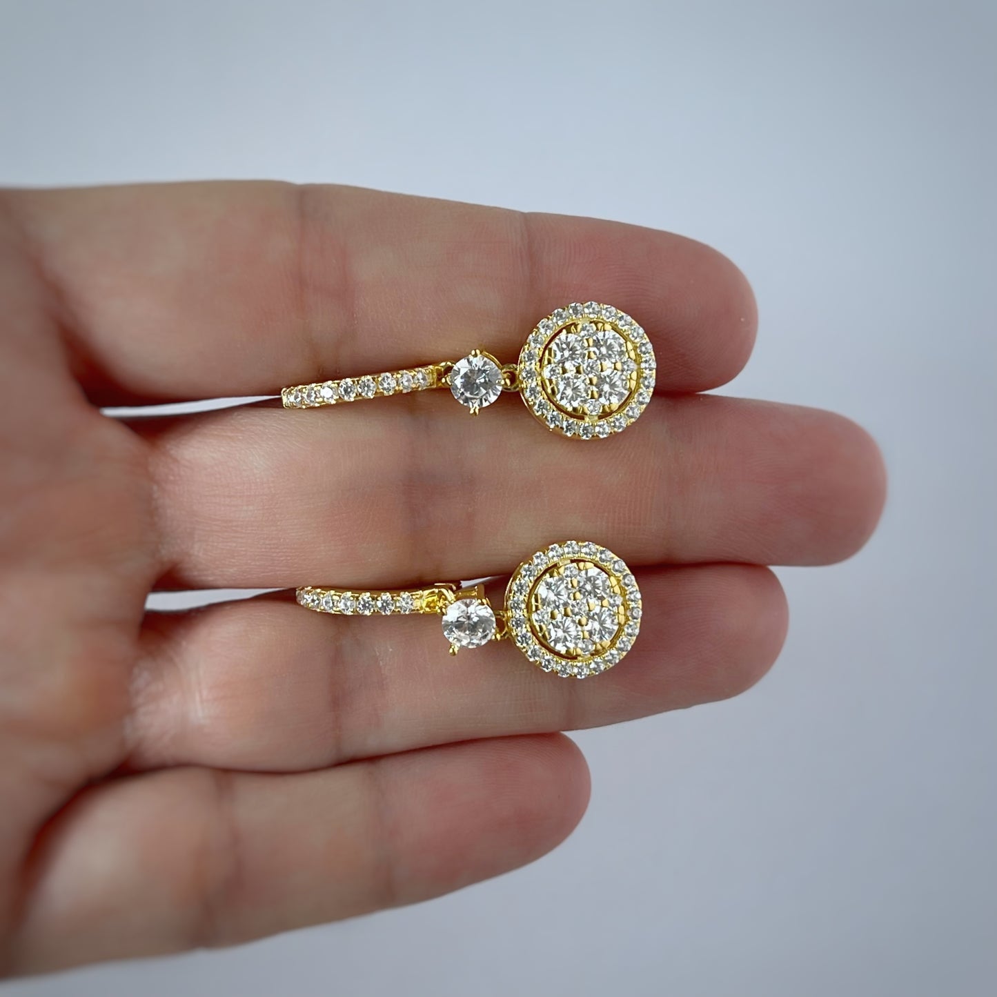 Argolla de plata con baño de oro amarillo y círculo colgante con halo de circonitas blancas