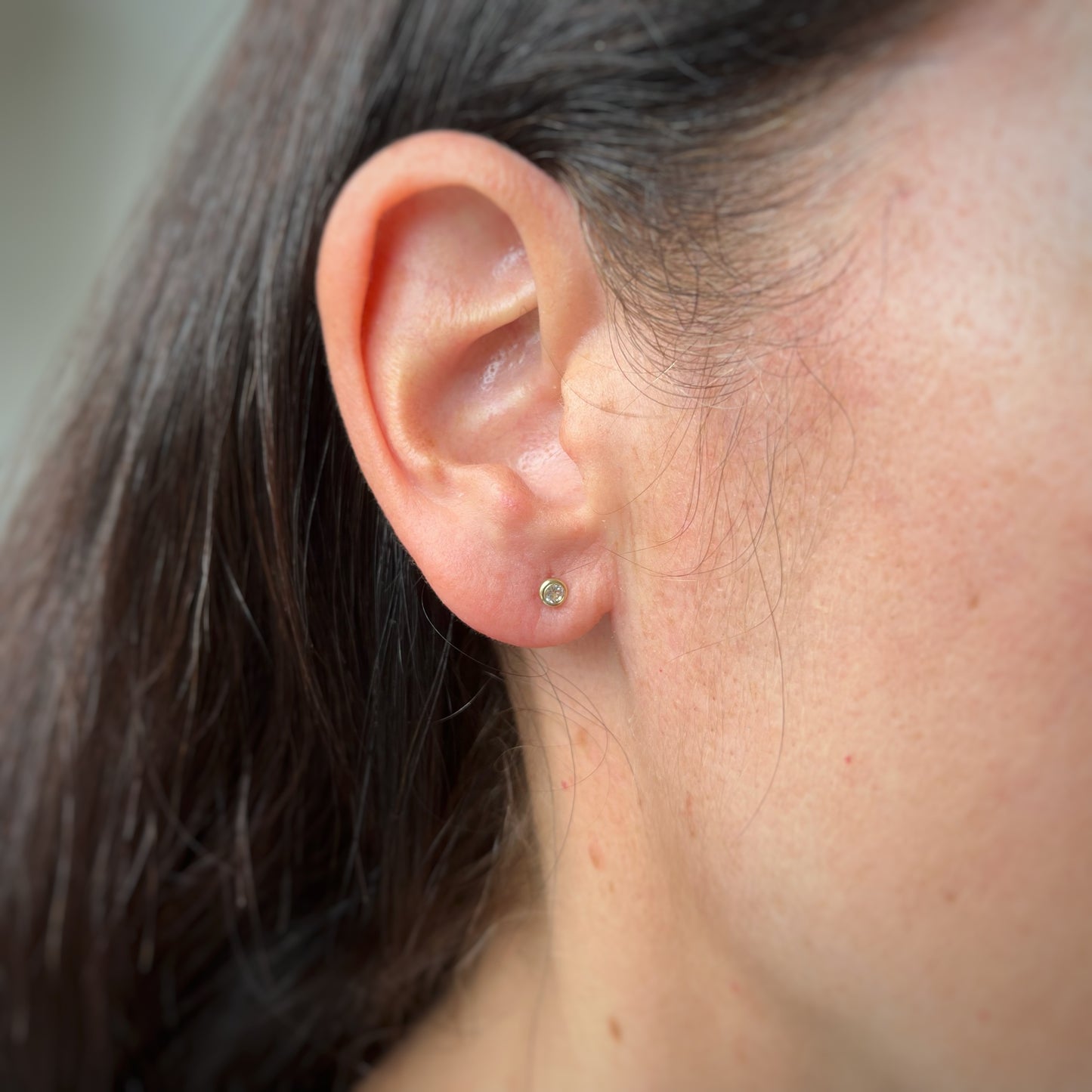 Aretes en oro amarillo 14k con circón biselado blanco con broche rosca