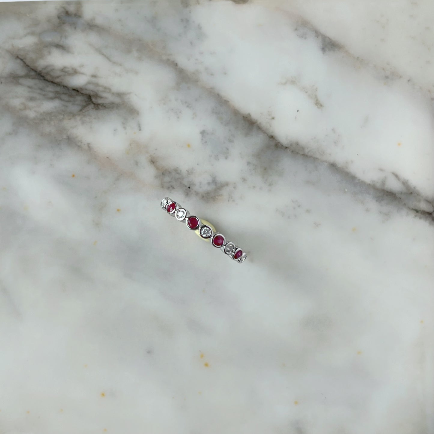 Medio cintillo de diamantes 0.15ctw y rubi biseladas en oro blanco 10k