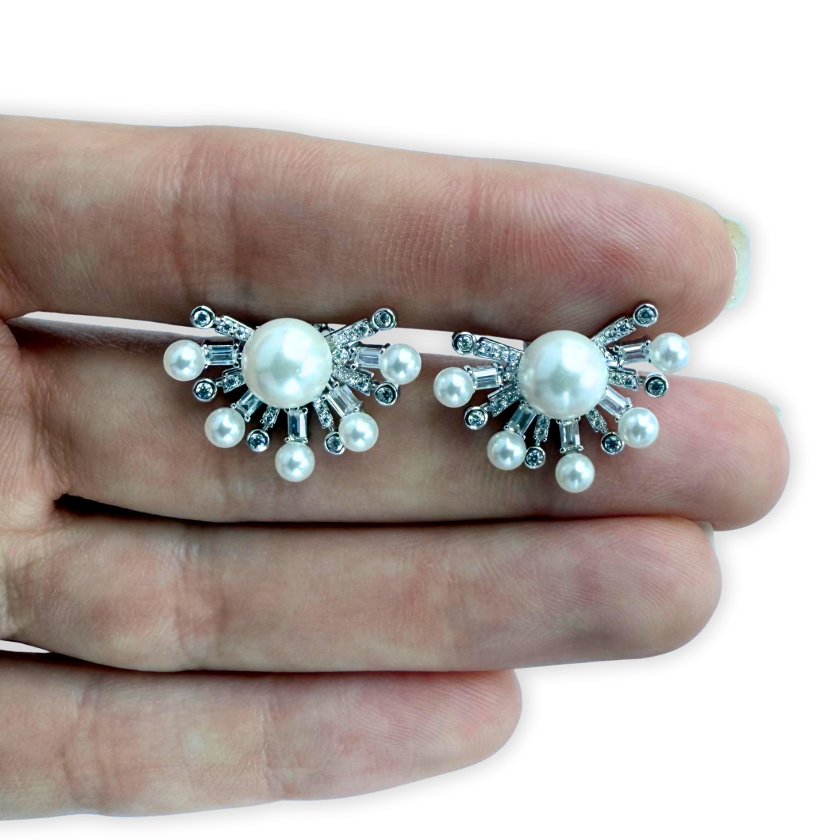 Aretes de plata con baño platino y media flor con perla en el centro y circonitas