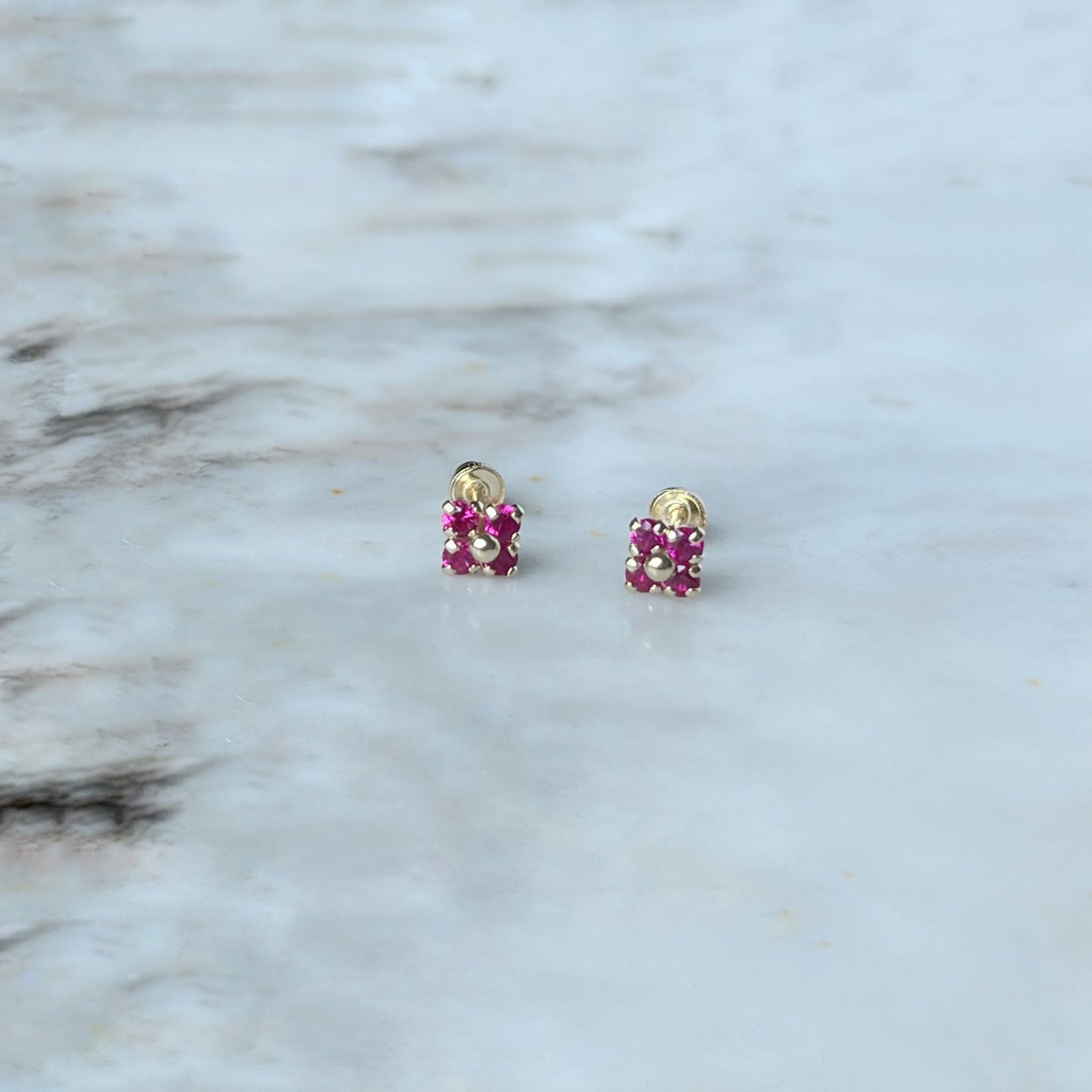 Aretes en oro amarillo 14k flores de circonitas roja con bolita de oro en el centro con broche rosca