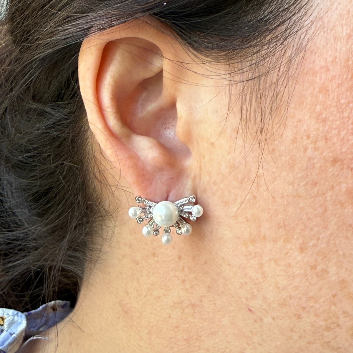 Aretes de plata con baño platino y media flor con perla en el centro y circonitas