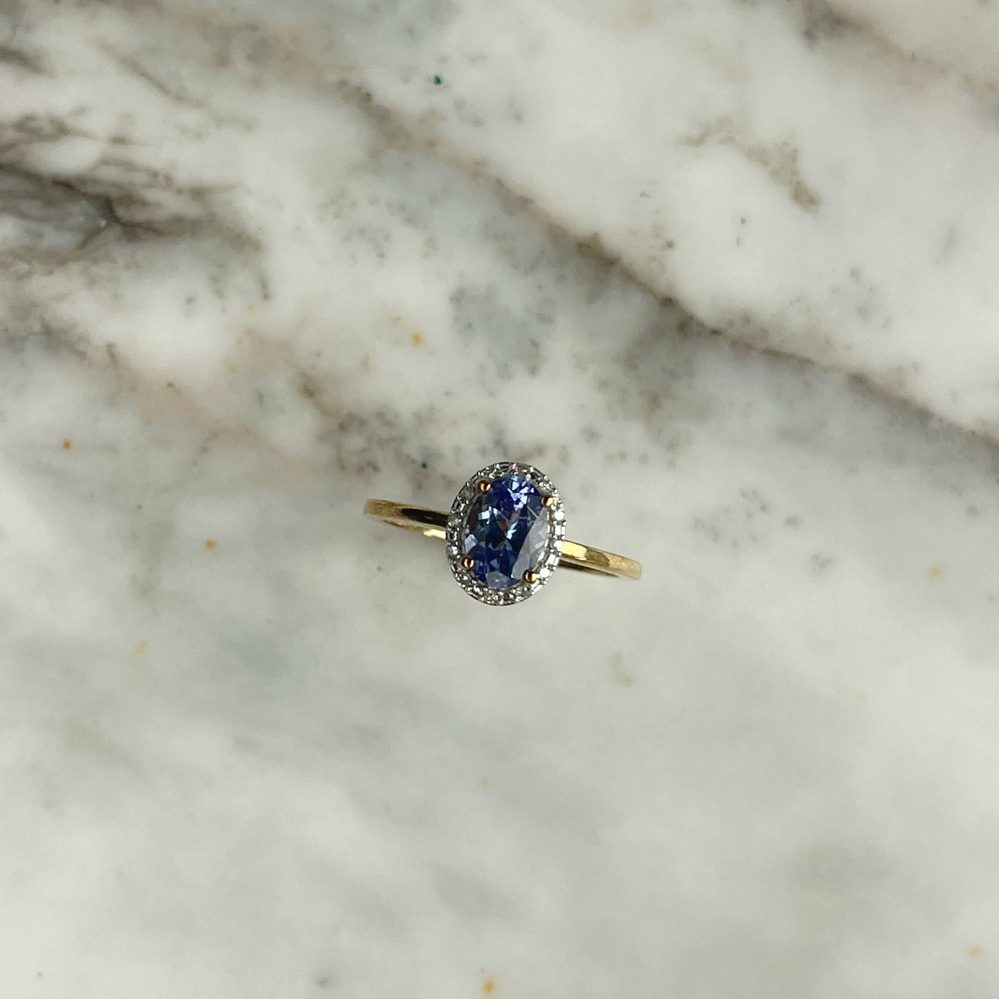 Anillo de oro amarillo 10k con tanzanita ovalada y halo de diamantes