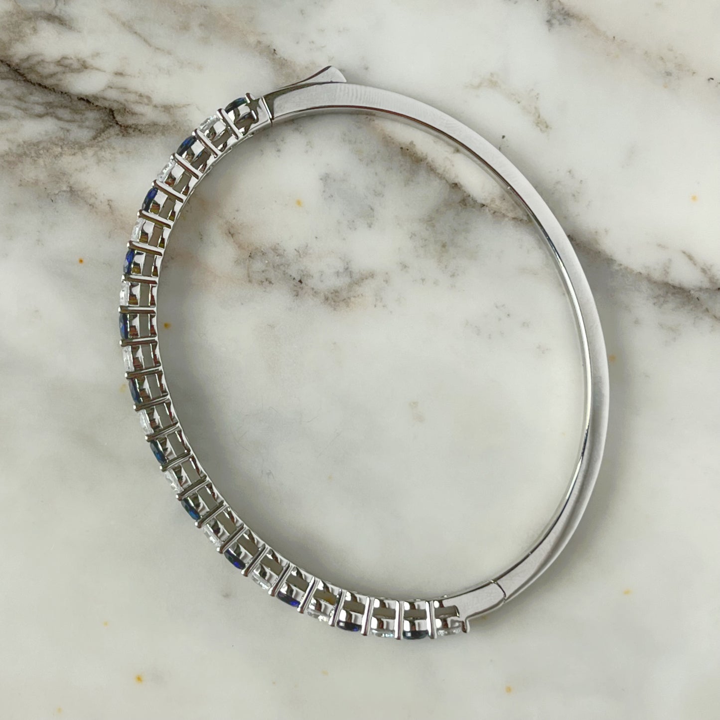 Pulsera dura de plata con baño platino y circonita blancas y azul zafiro