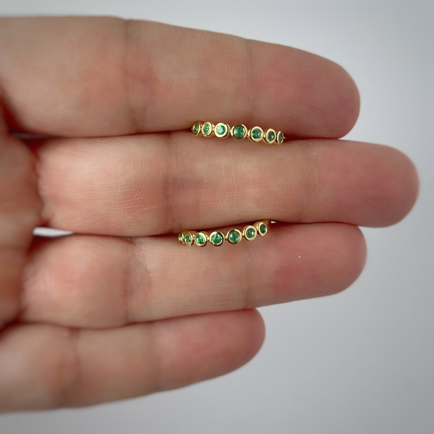 Argollas redondas en oro amarillo 10k con esmeraldas bieladas