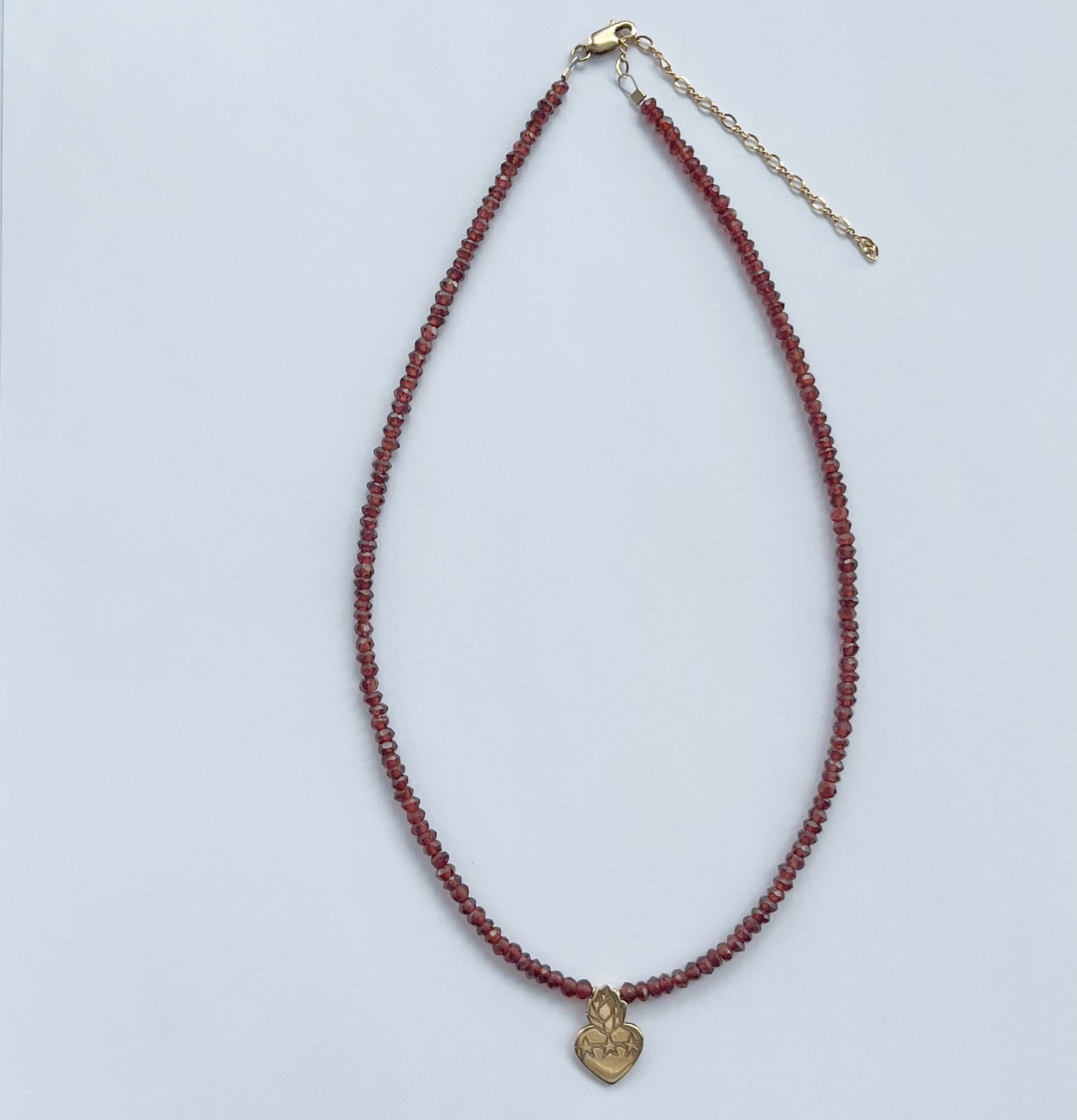 Collar de granates con sagrado corazón en plata con baño de oro amarillo y broche con cadena en goldfill