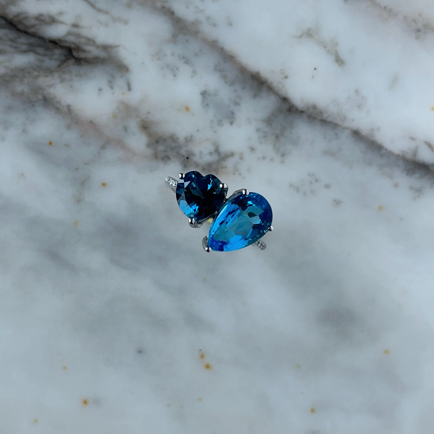 Anillo en oro blanco 10k con topacios azules corazón y gota y diamantes 0.08ctw