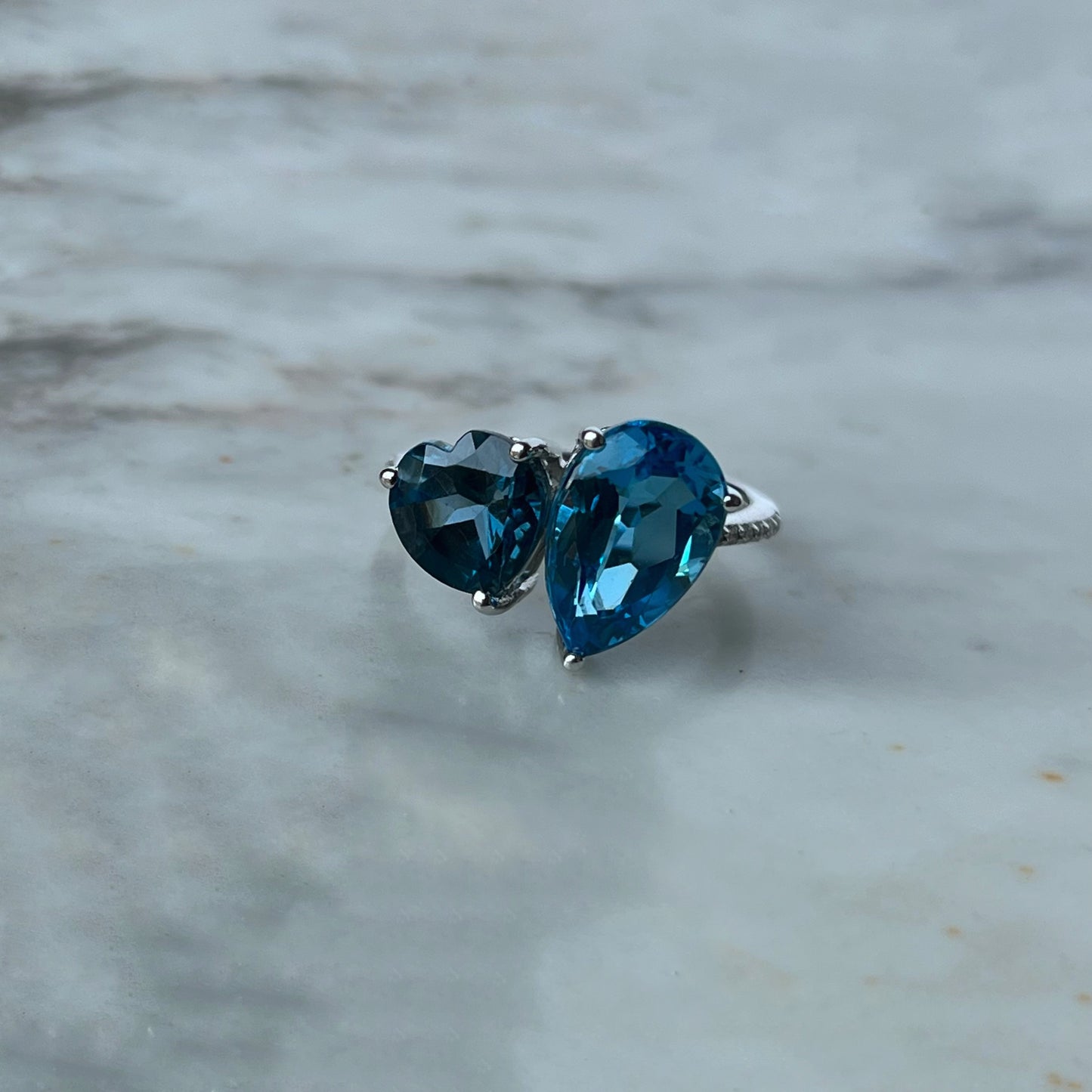 Anillo en oro blanco 10k con topacios azules corazón y gota y diamantes 0.08ctw