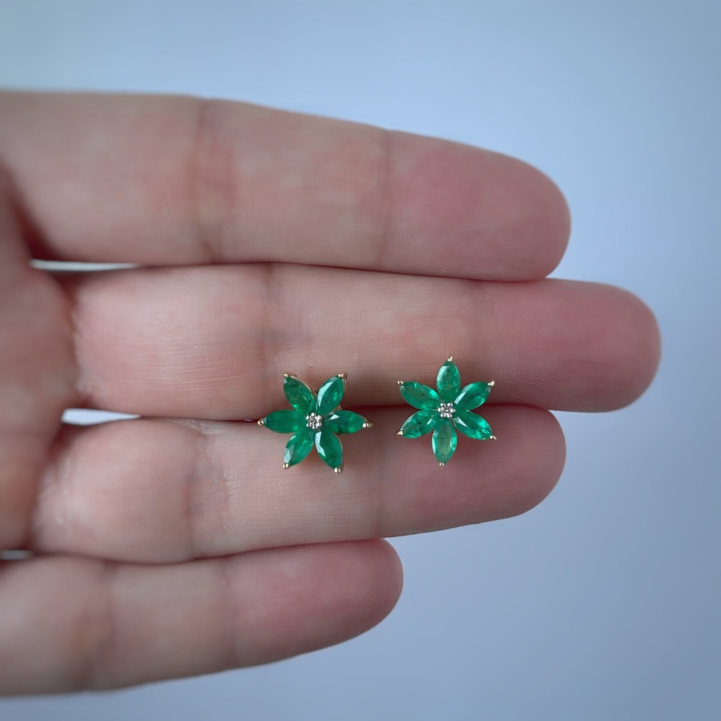 Aretes de flor de seis pétalos en oro amarillo 10K con esmeraldas y diamantes
