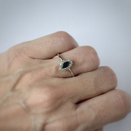 Anillo oro blanco 14K con zafiro corte marquesa 0.21ct y halo de diamantes 0.13ctw