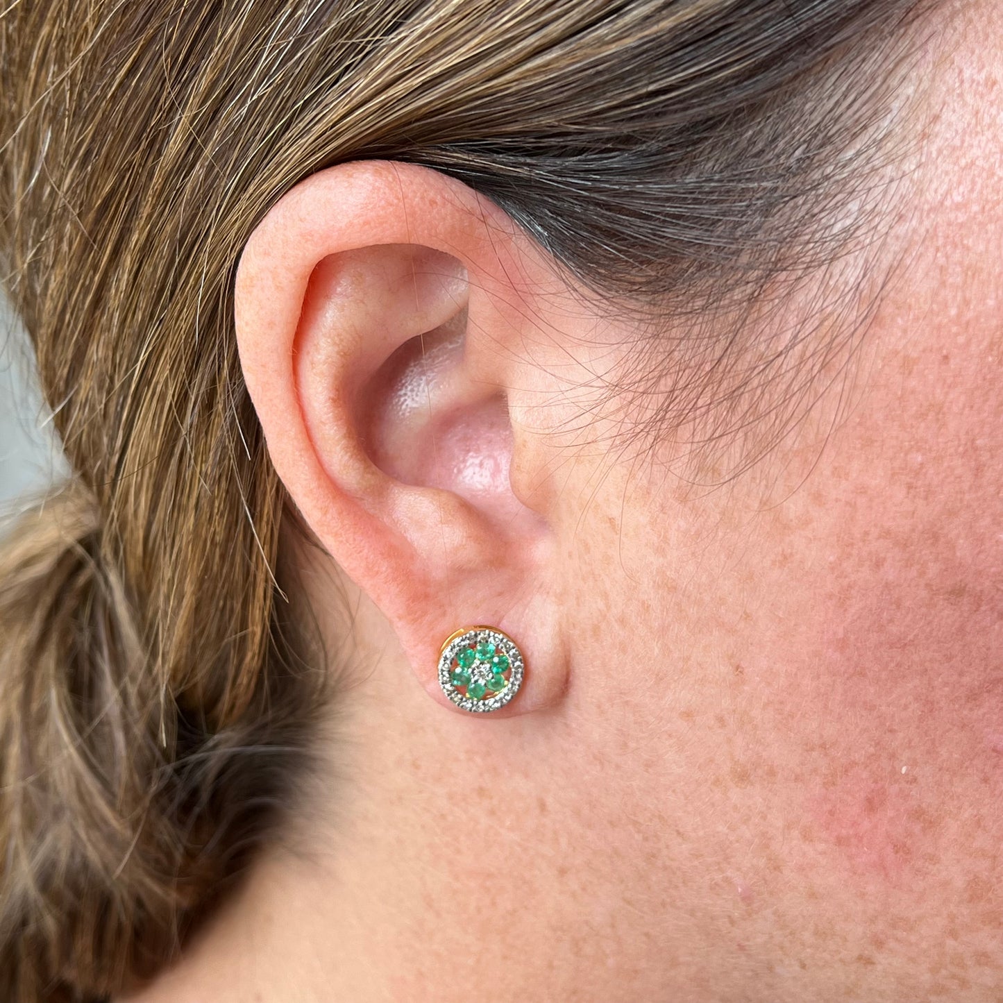 Aretes en oro amarillo 10k con flor de esmeralda y halo de diamantes 0.25ctw