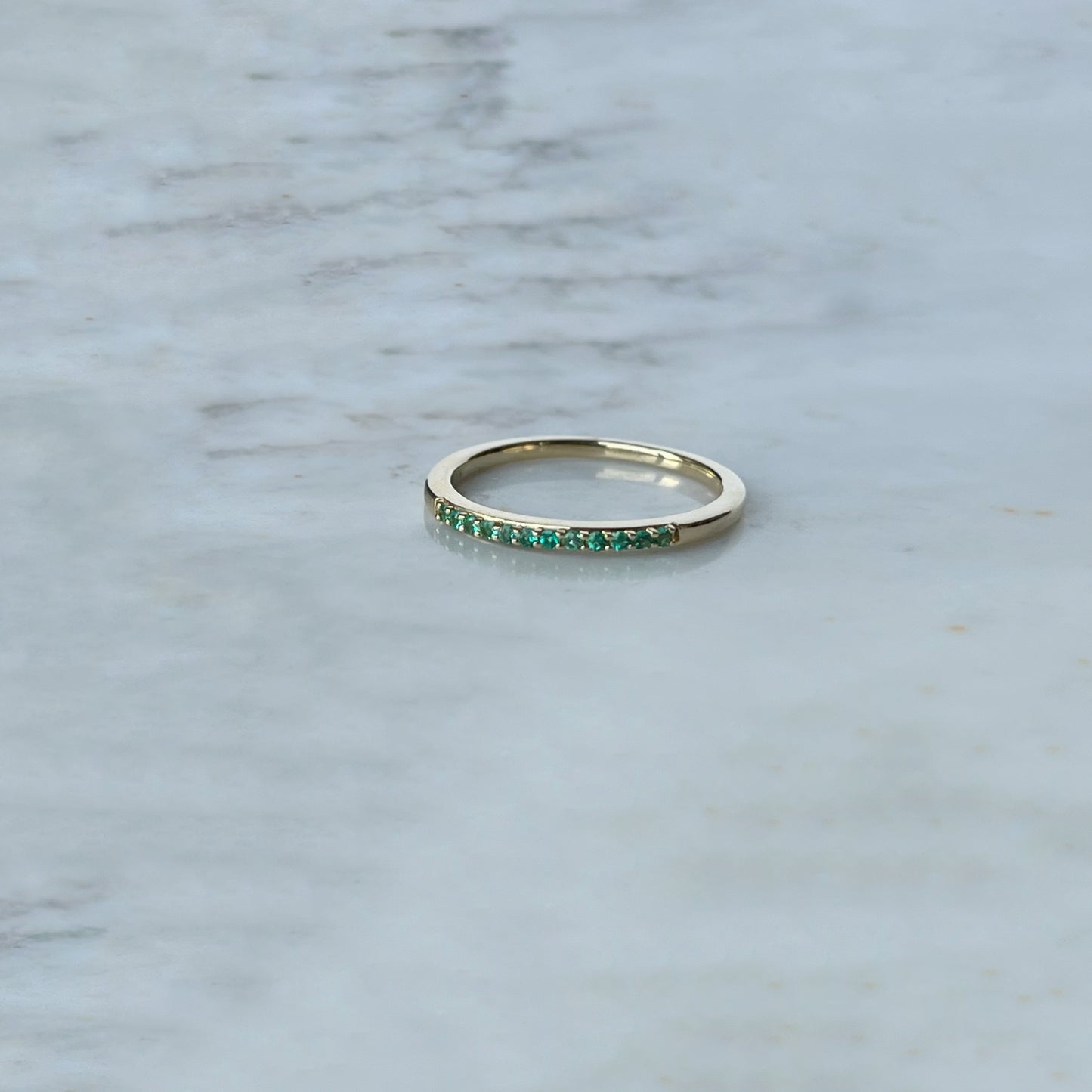 Anillo medio cintillo en oro amarillo 14k con esmeraldas
