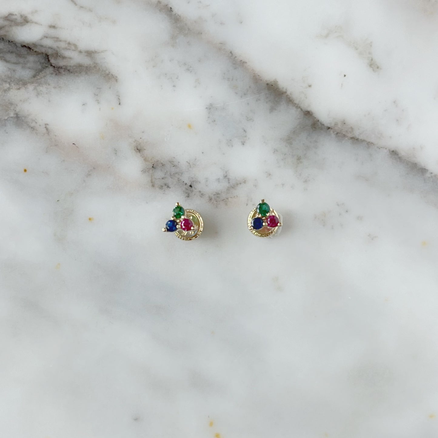 Aretes tres circonitas de color fucsia, azul y verde en oro amarillo de 14k con tope rosca
