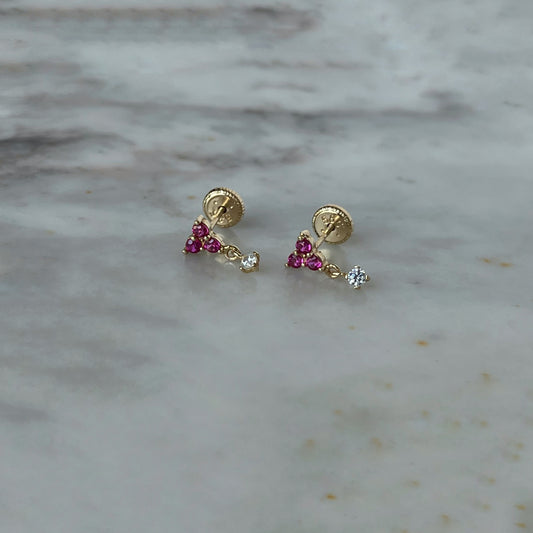 Arete con tres circonitas fucsia y una circonita colgante en oro amarillo de 14K con tope rosca