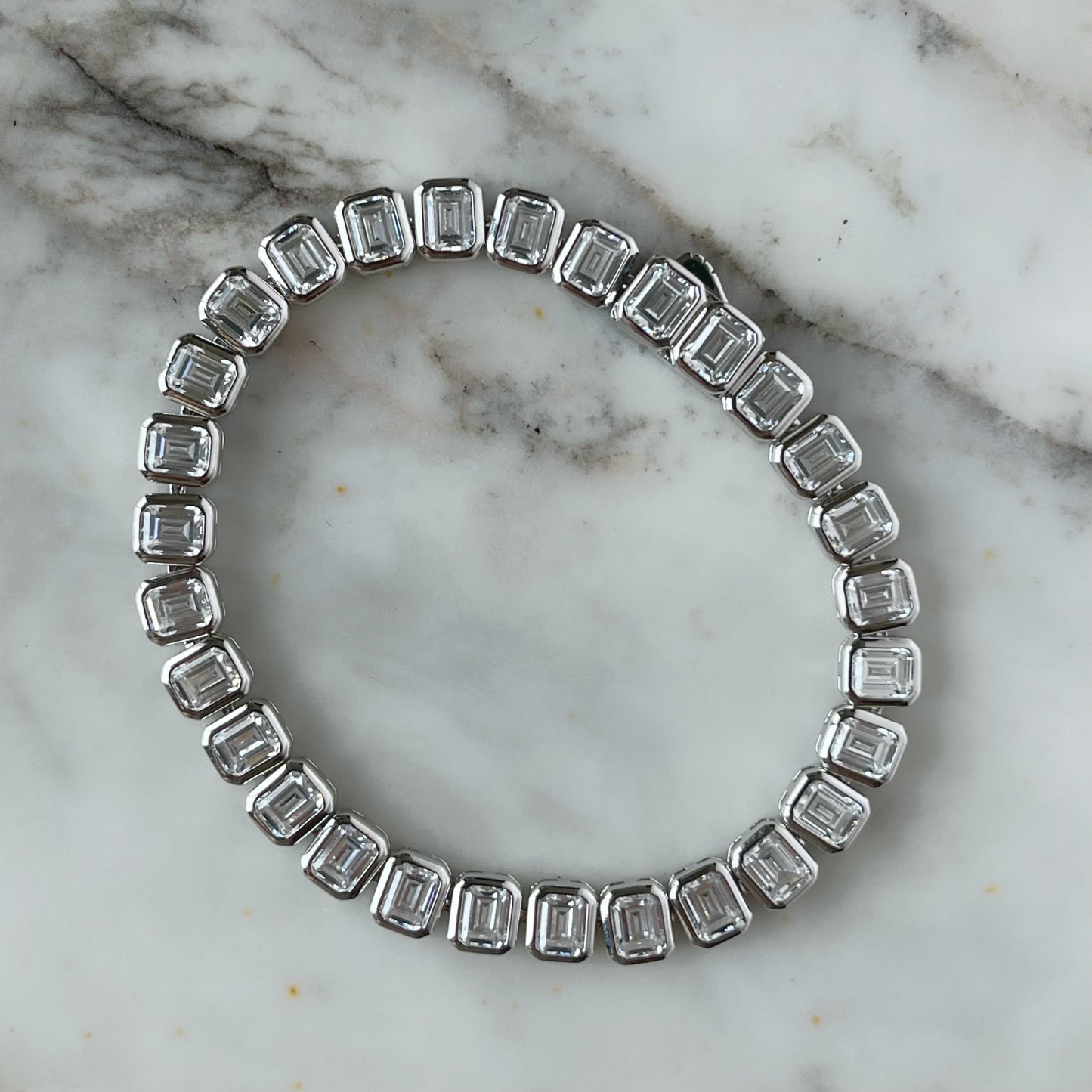 Pulsera tipo tenis con circonitas corte esmeralda biseladas 12ctw