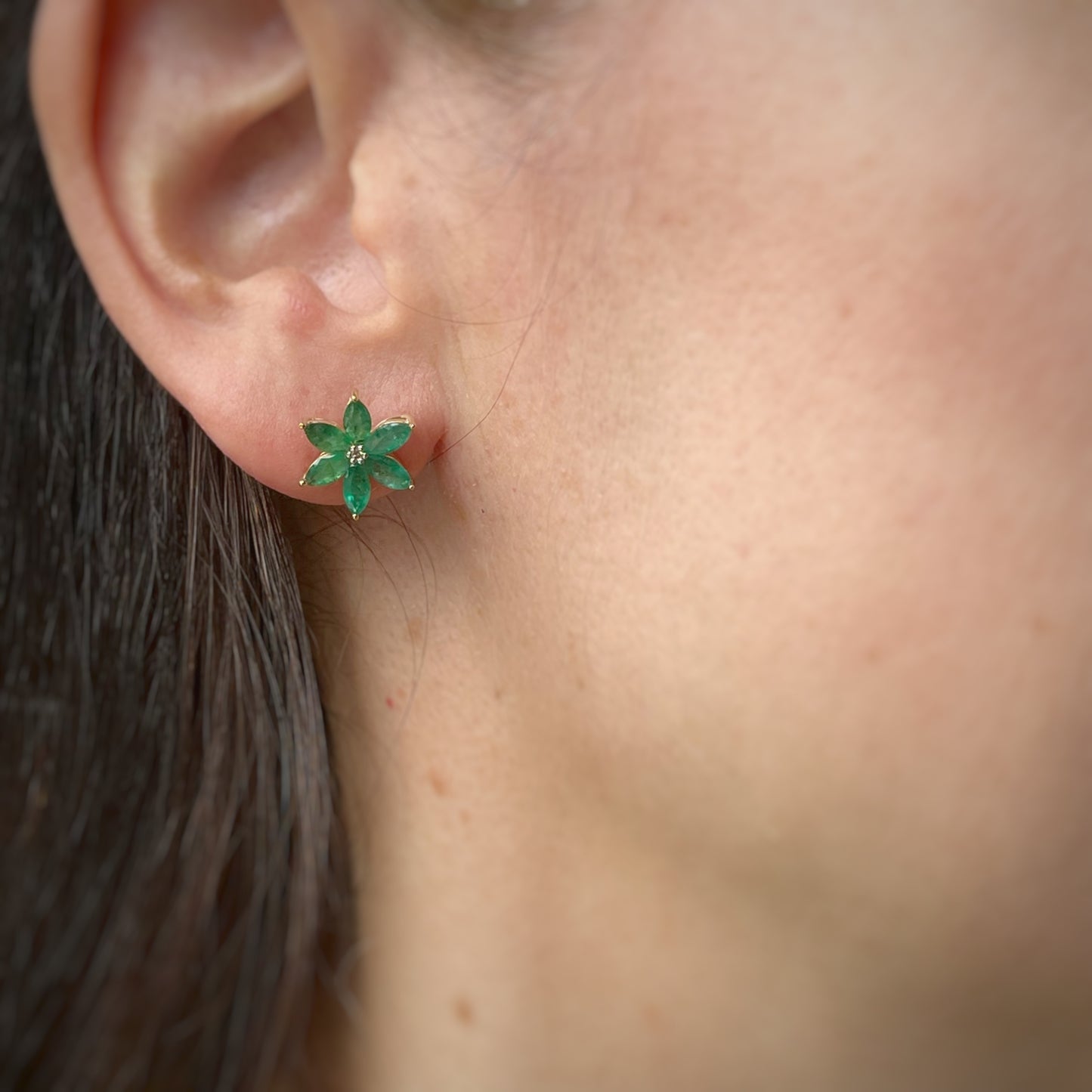 Aretes de flor de seis pétalos en oro amarillo 10K con esmeraldas y diamantes