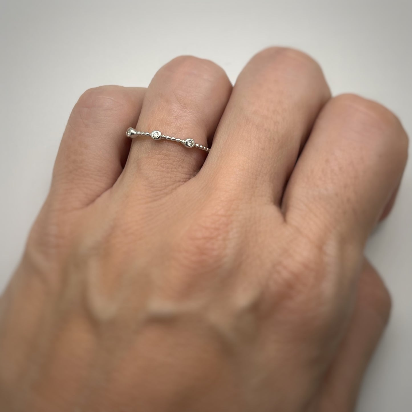 Anillo en oro blanco 14k de bolitas con 3 diamantes