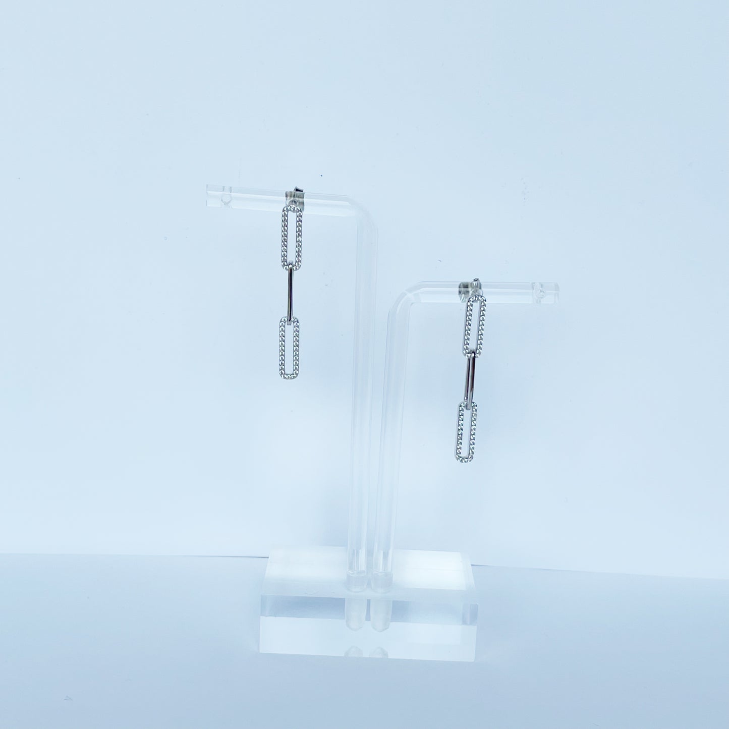 Arete largo paper clip de plata con baño platino y circonitas blancas