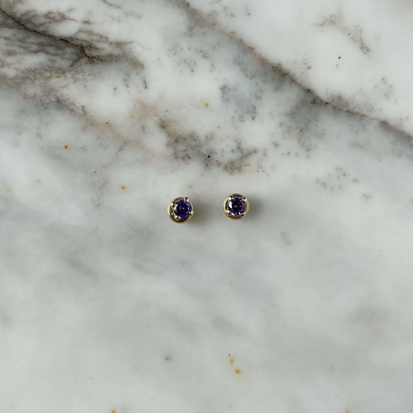 Aretes en oro amarillo 14k con circonita morada con broche rosca