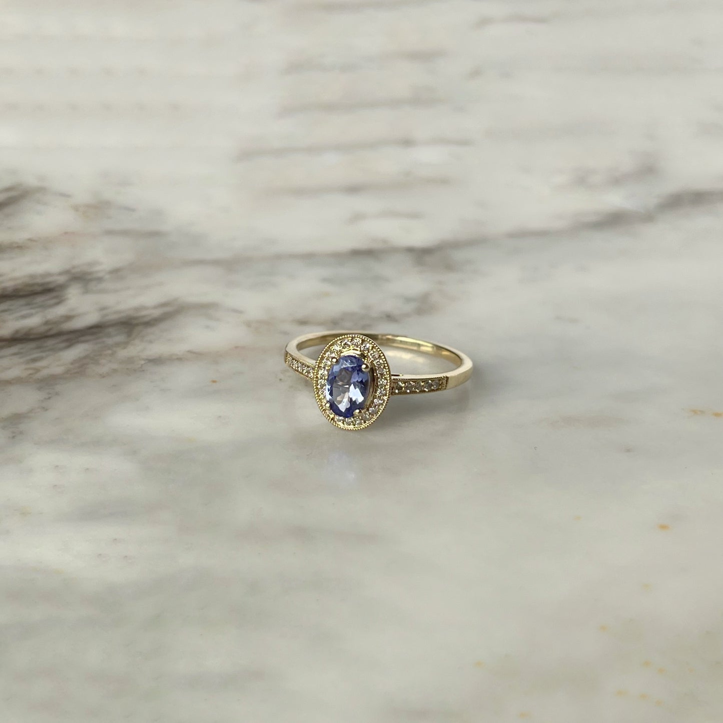 Anillo en oro amarillo 10k con tanzanita ovalada y diamantes 0.12ctw