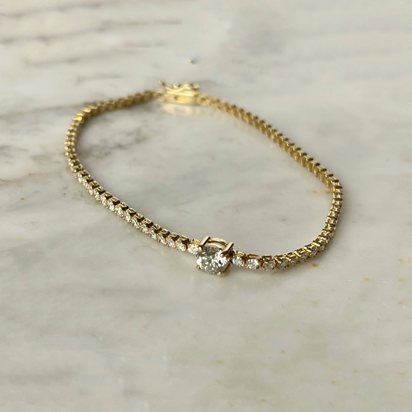 Pulsera tenis en oro amarillo 18k con diamante redondo central 1.6ctw
