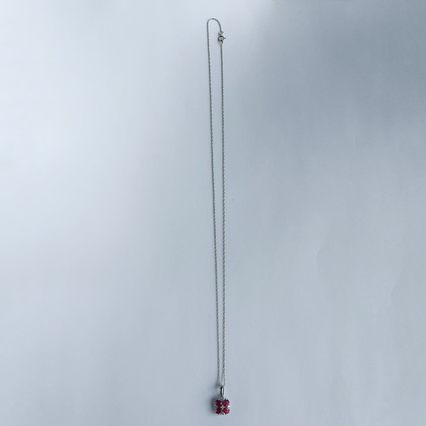 Collar en oro blanco 10k con flor de rubíes y diamantes 0.06ct