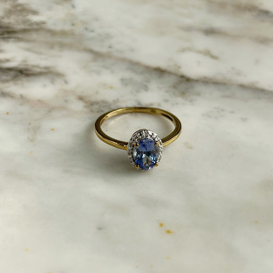 Anillo de oro amarillo 10k con tanzanita ovalada y halo de diamantes