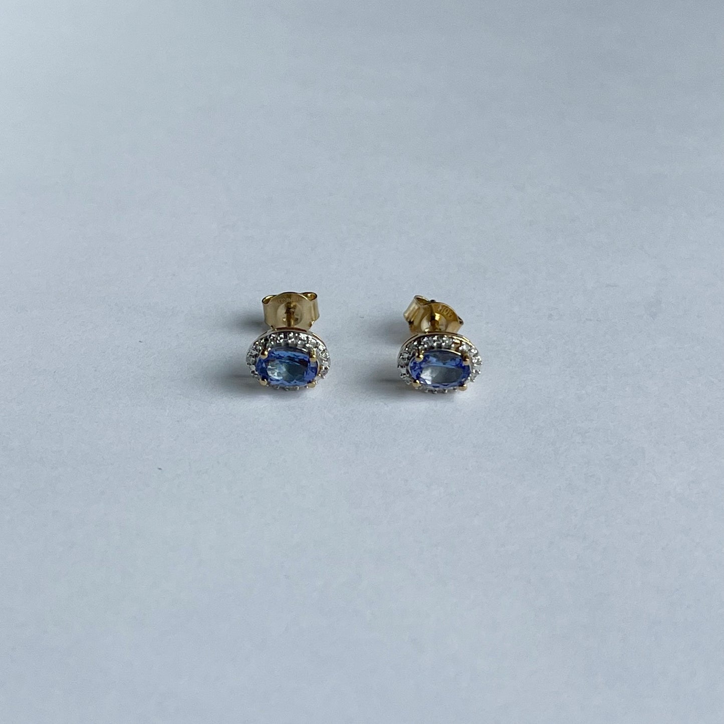 Aretes en oro amarillo 10k con tanzanita ovalada y halo de diamantes