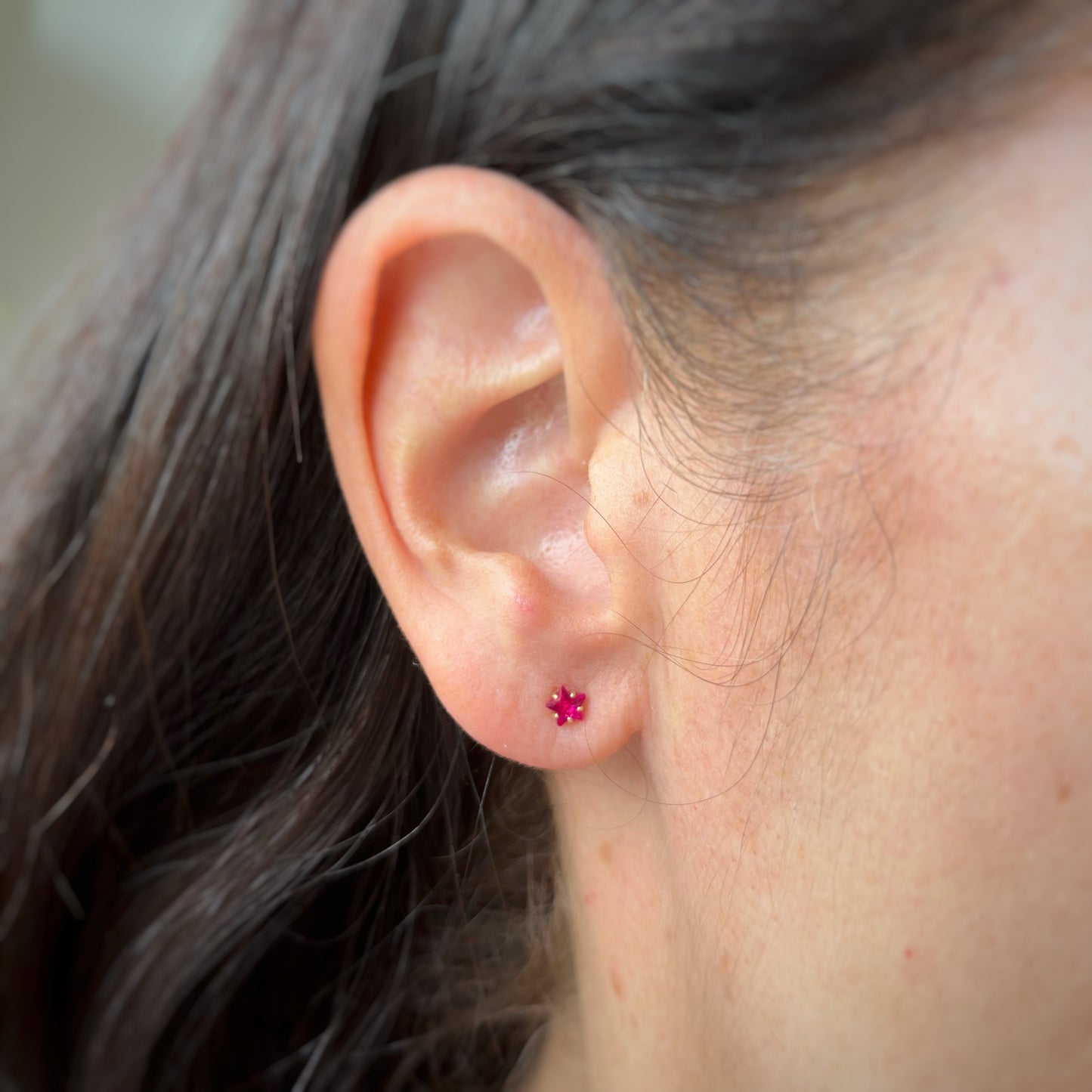 Aretes en oro amarillo 14k estrellas de circonitas rojas con broche rosca