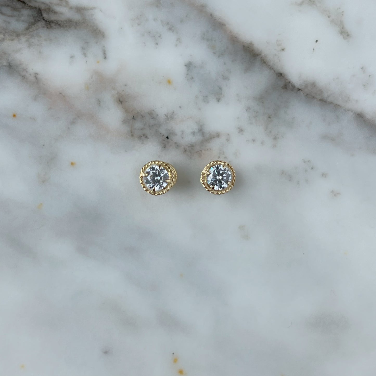 Aretes en oro amarillo 18k con circonita blanca y borde trenzado con broche rosca